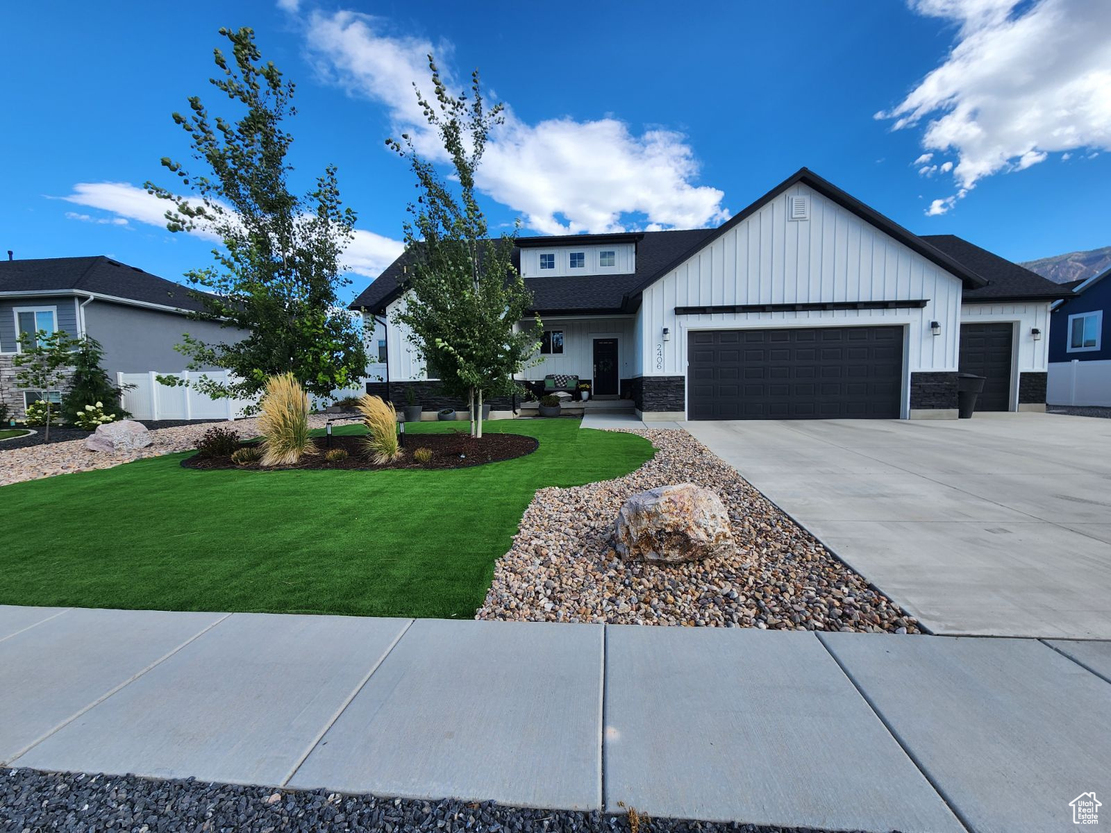 View of front of property featuring a front lawn and a garage