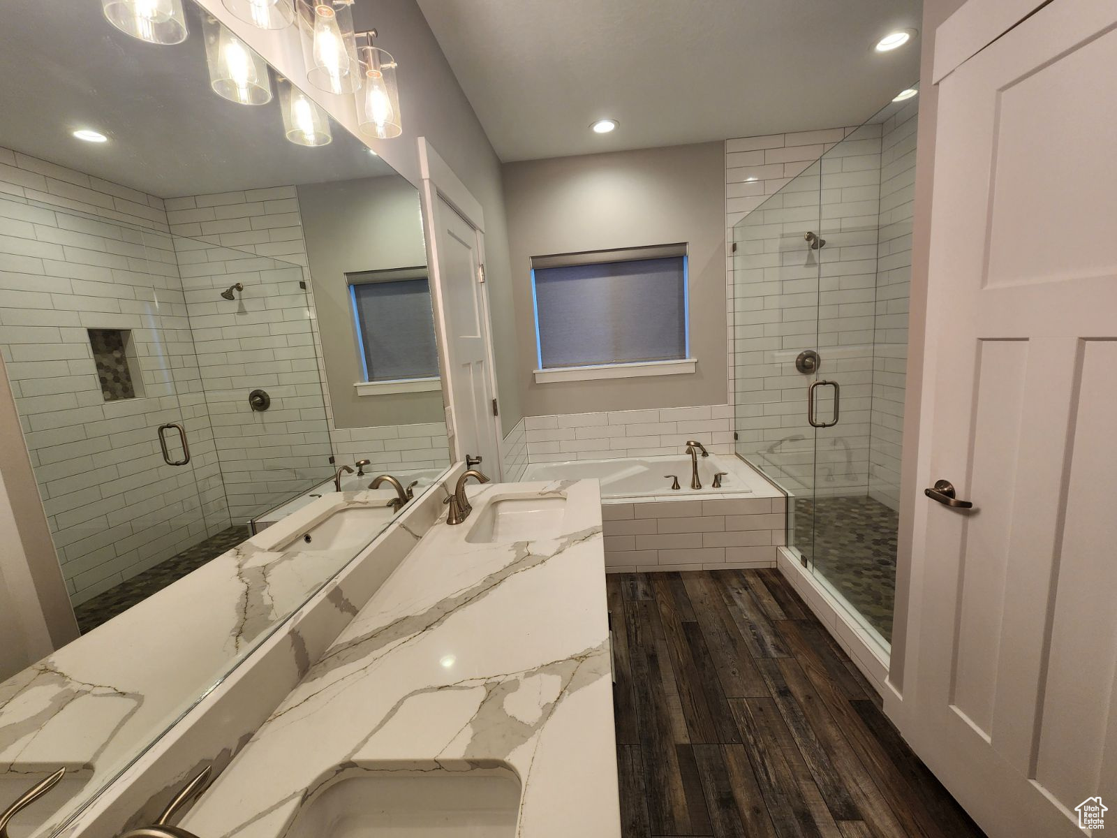 Bathroom with hardwood / wood-style flooring, shower with separate bathtub, and vanity