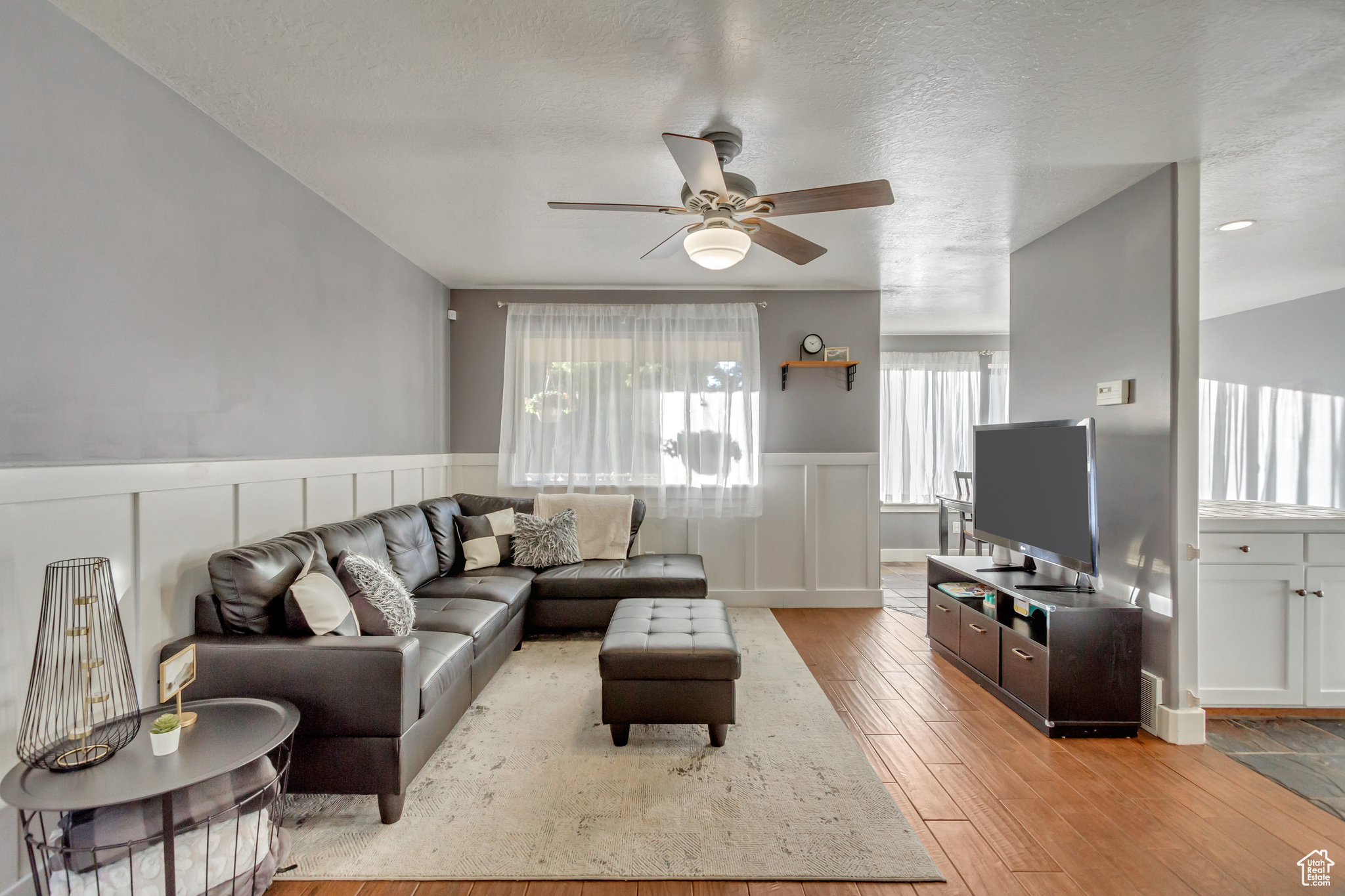 Living room featuring ceiling fan, light hardwood / wood-style flooring, and a textured ceiling