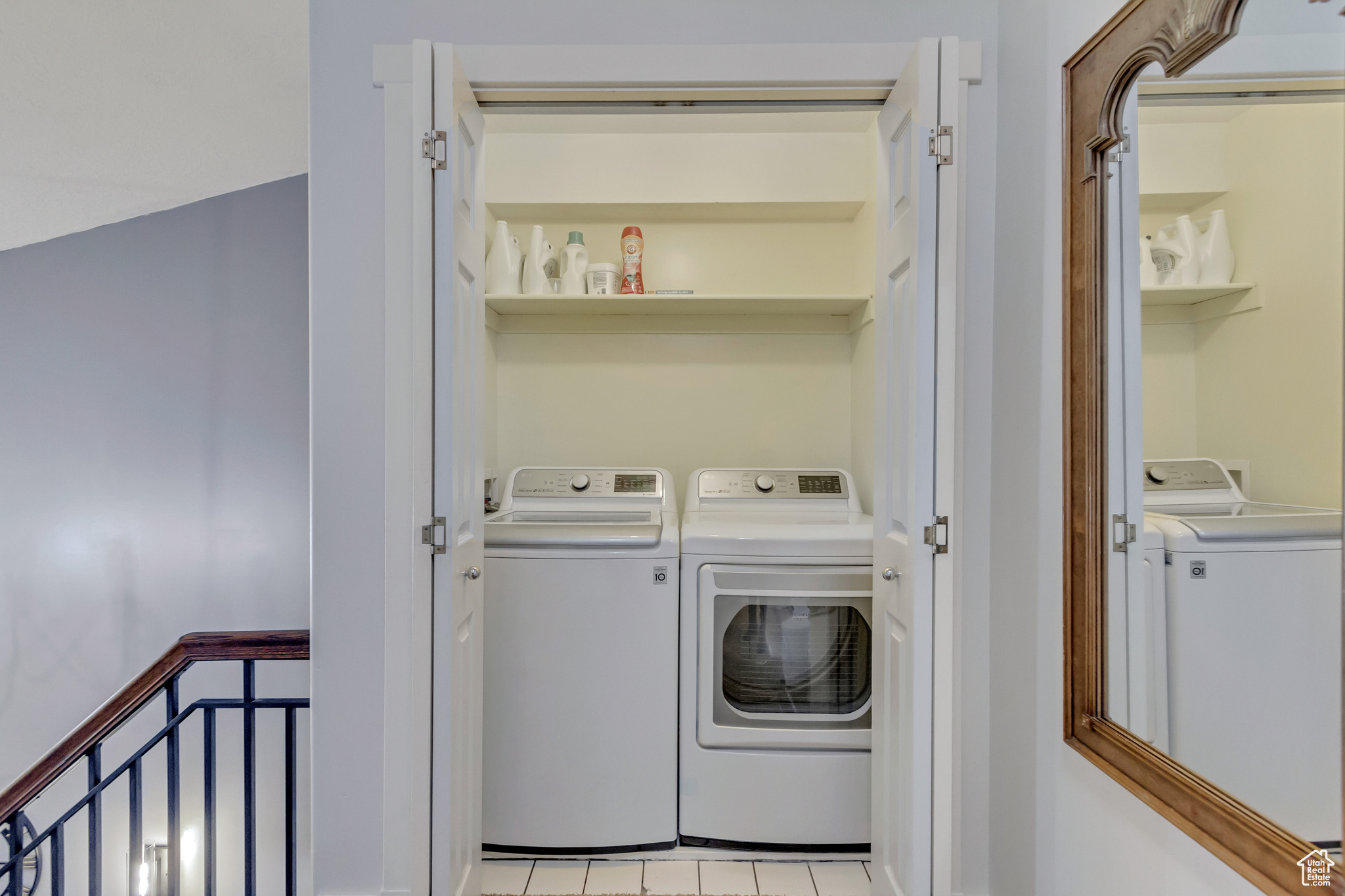 Laundry room with washer and clothes dryer and light tile patterned floors