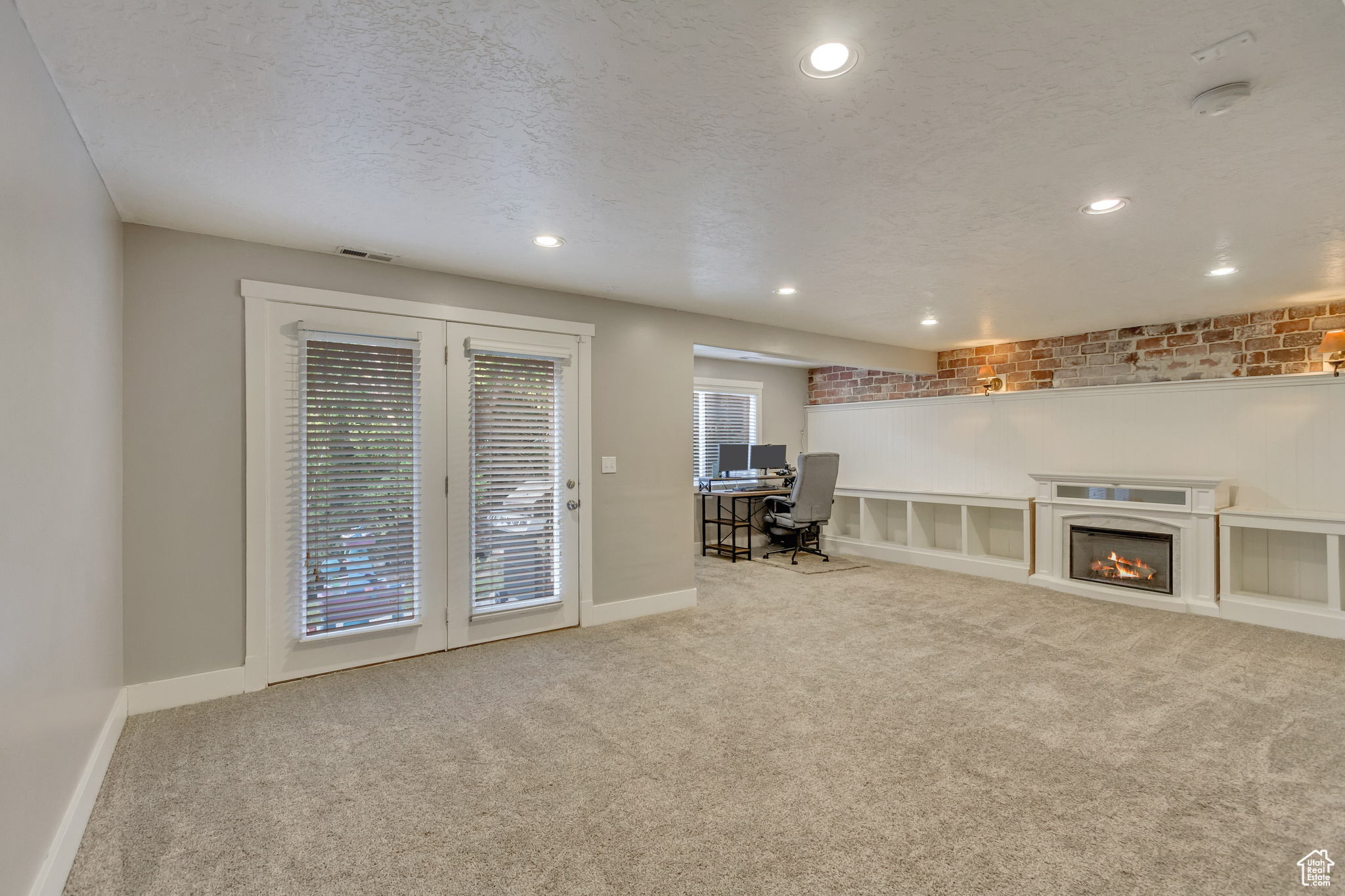 Unfurnished living room featuring light carpet and a textured ceiling