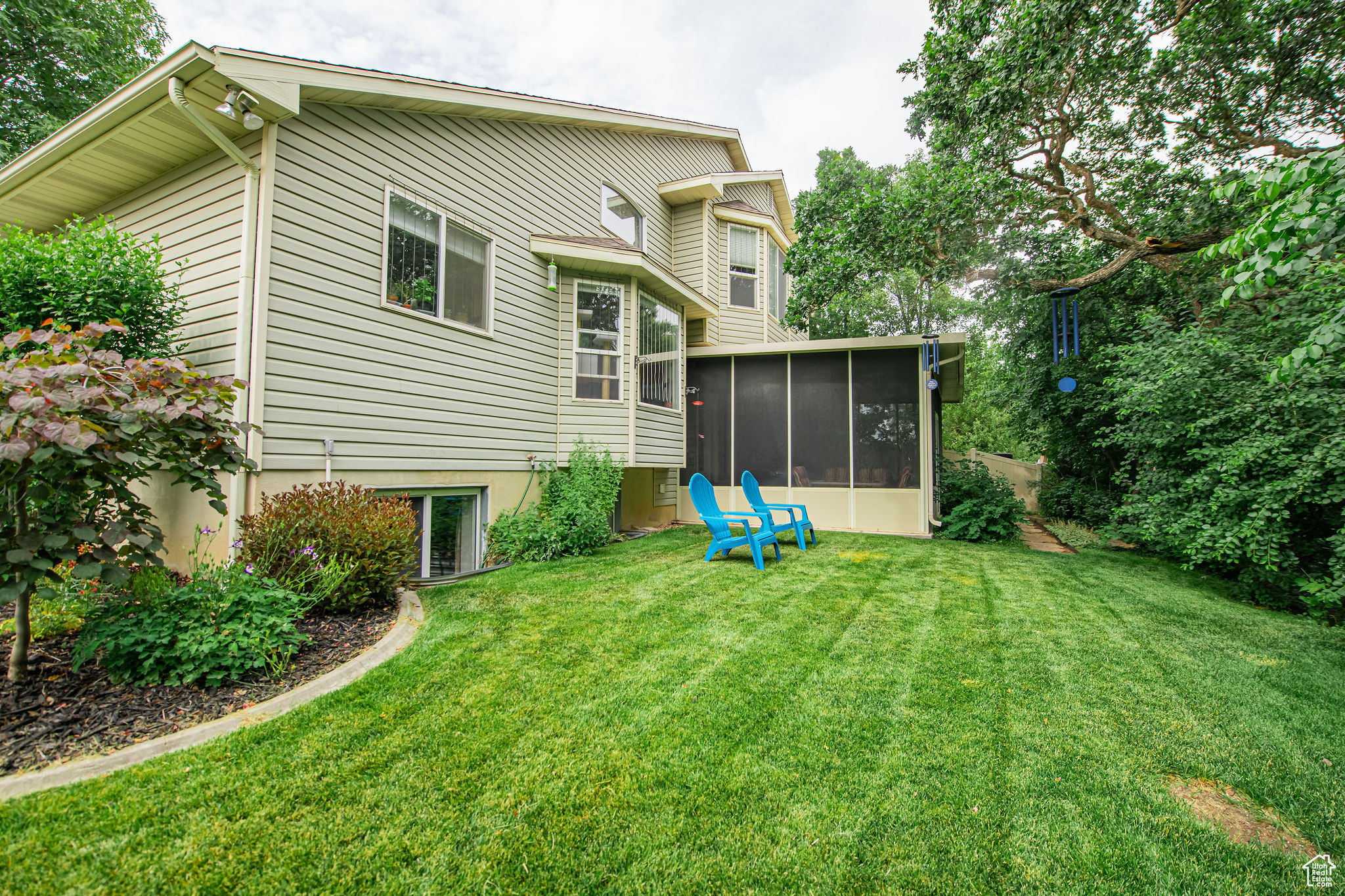 Rear view of house featuring a yard and a sunroom