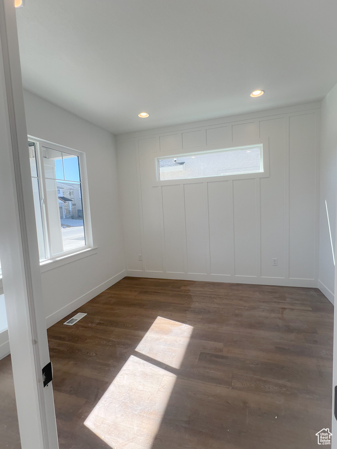 Empty room with dark hardwood / wood-style flooring