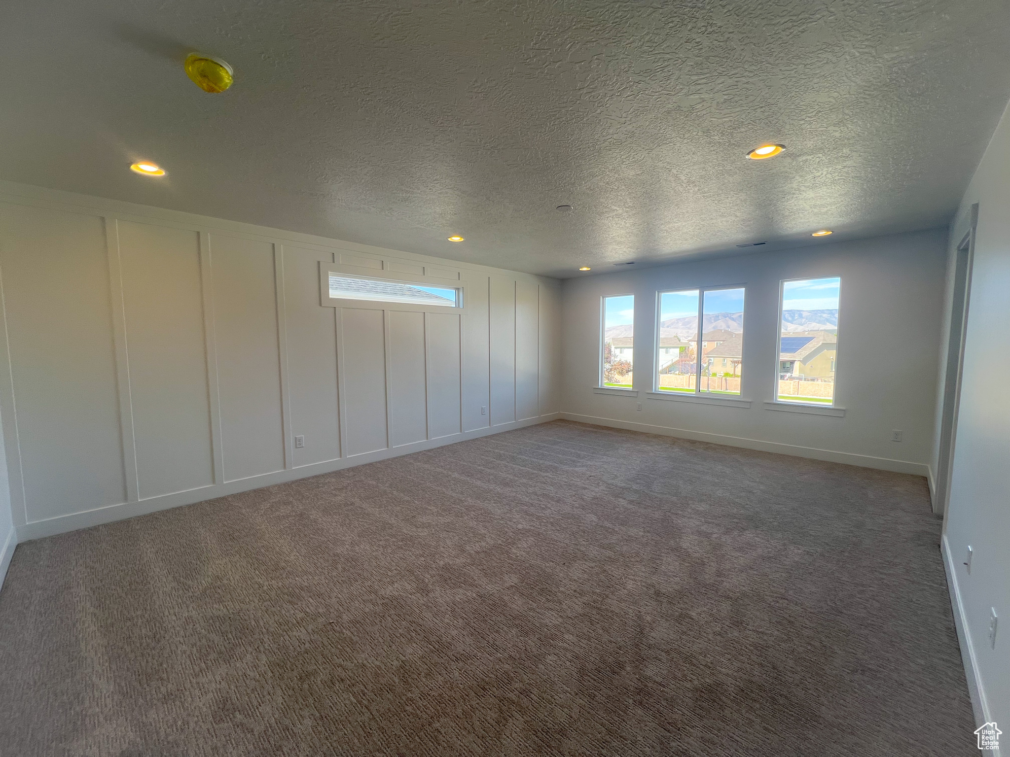 Carpeted spare room featuring a textured ceiling