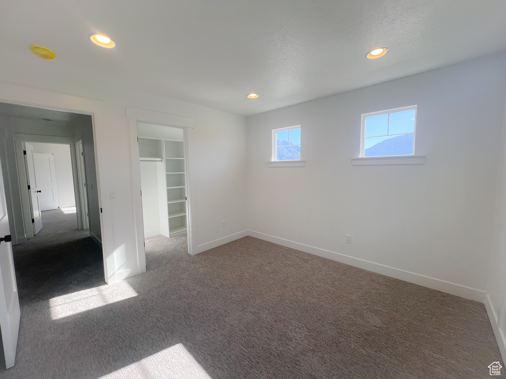 Unfurnished bedroom featuring a spacious closet, a closet, and carpet