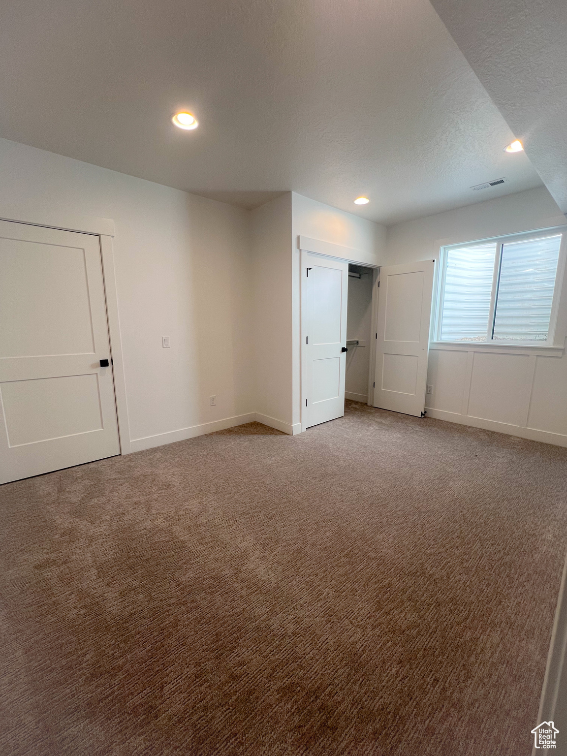 Unfurnished bedroom featuring light carpet