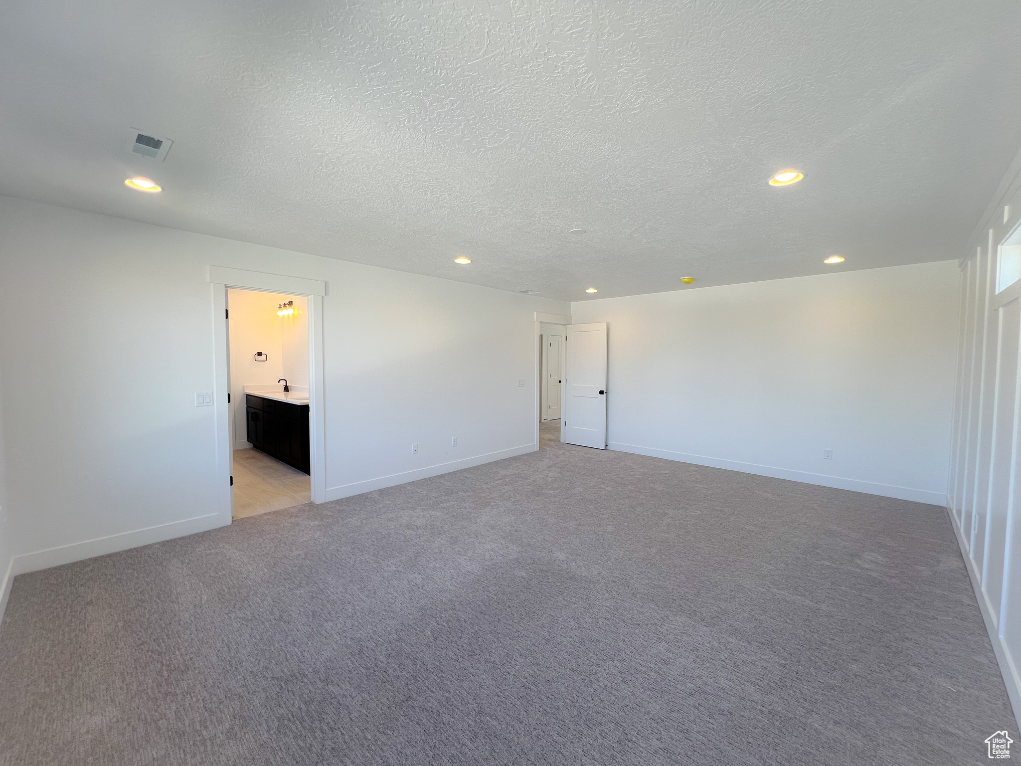 Carpeted spare room featuring a textured ceiling