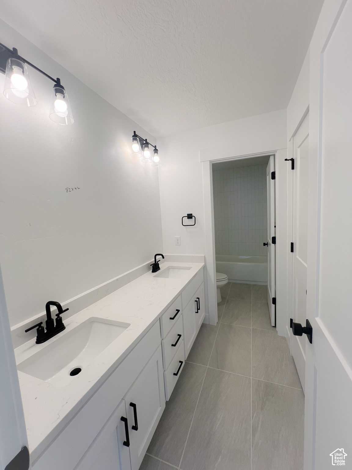 Full bathroom with tile patterned flooring, shower / bath combination, vanity, and toilet