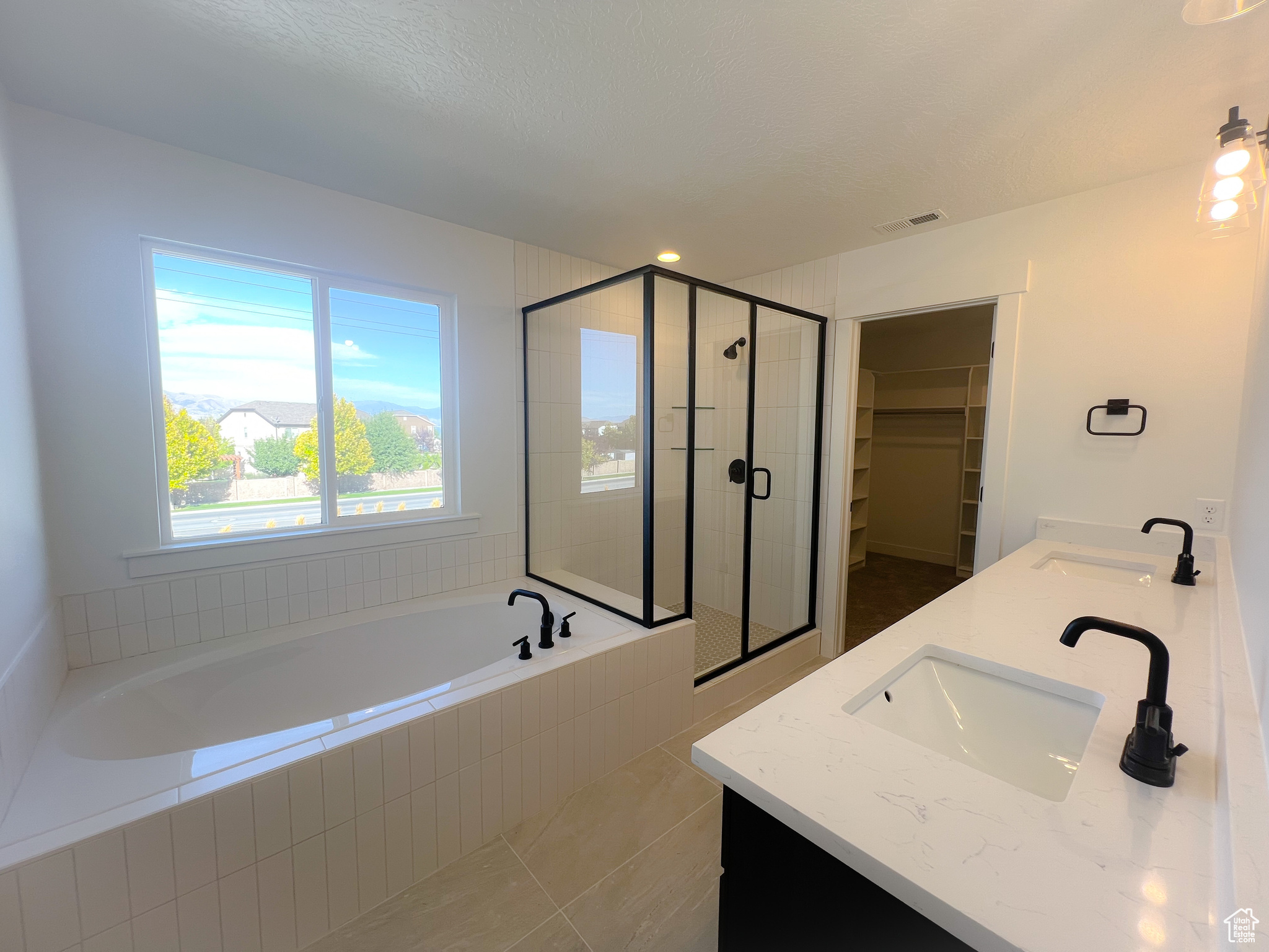 Bathroom with tile patterned flooring, independent shower and bath, and vanity