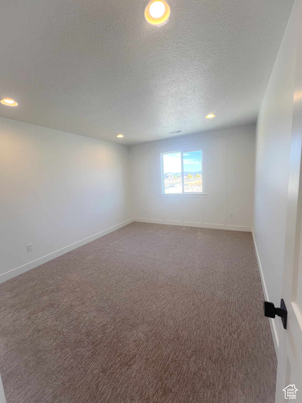 Spare room featuring carpet and a textured ceiling