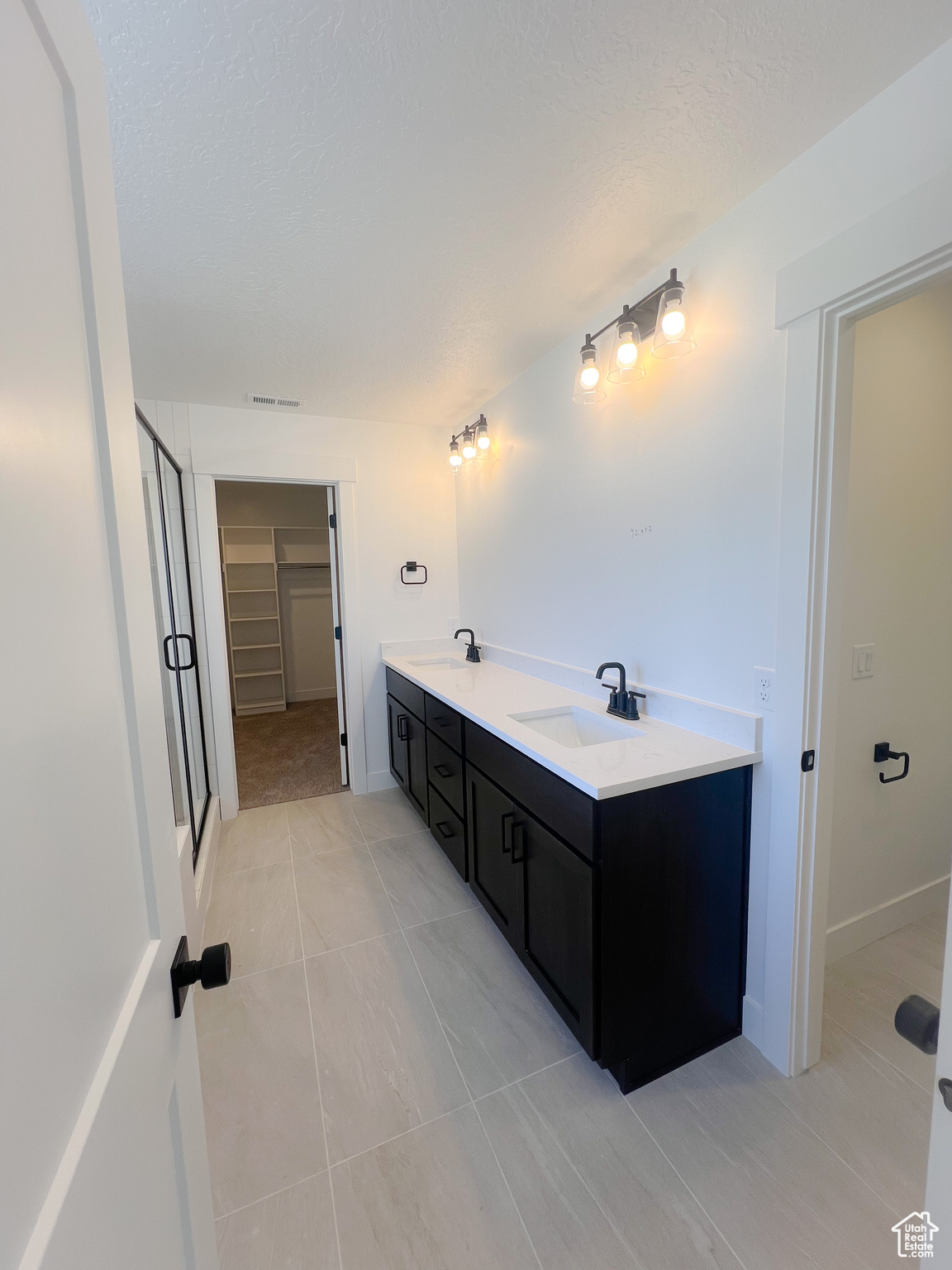 Bathroom featuring an enclosed shower, vanity, and tile patterned floors