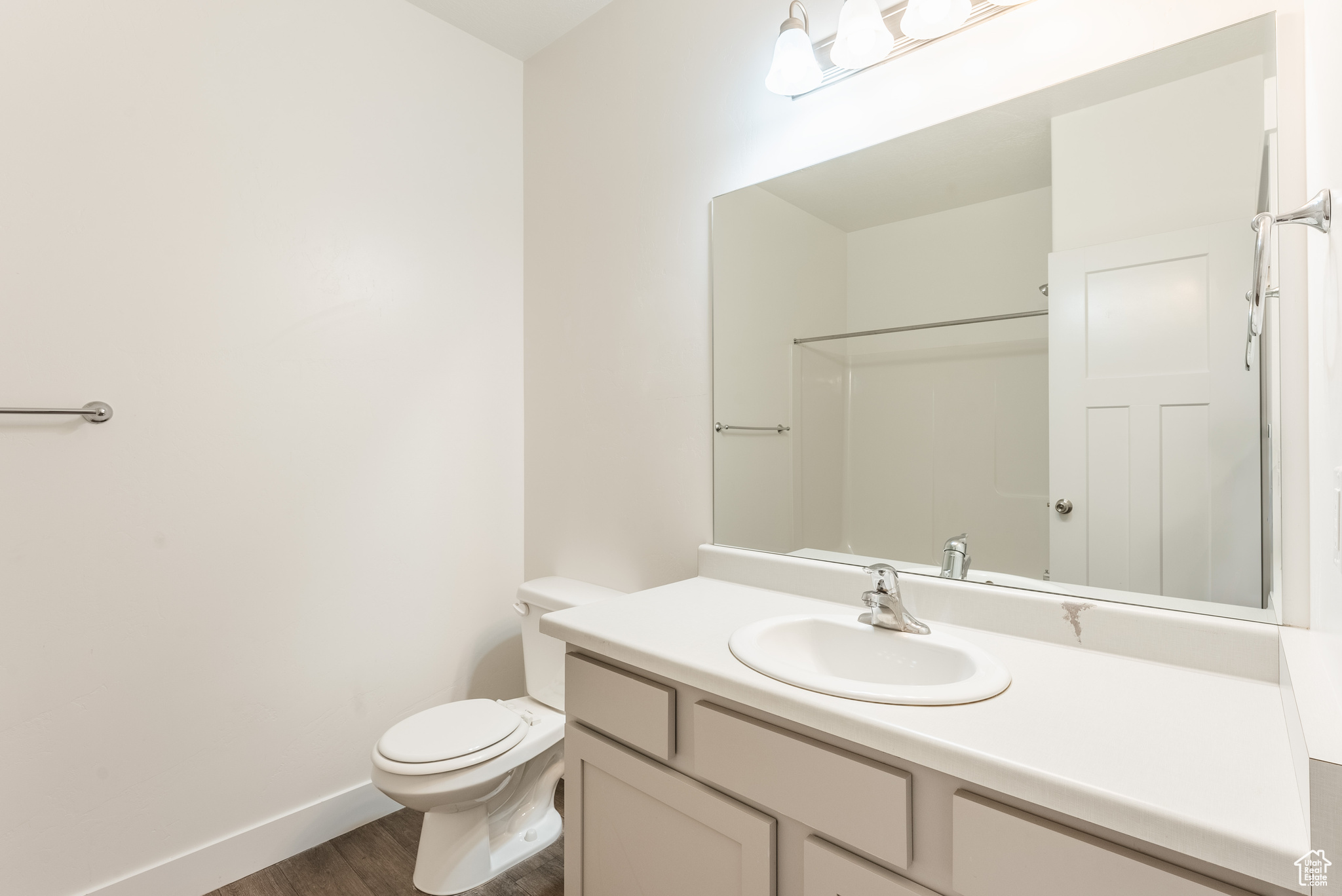 Bathroom featuring a shower, vanity, hardwood / wood-style floors, and toilet