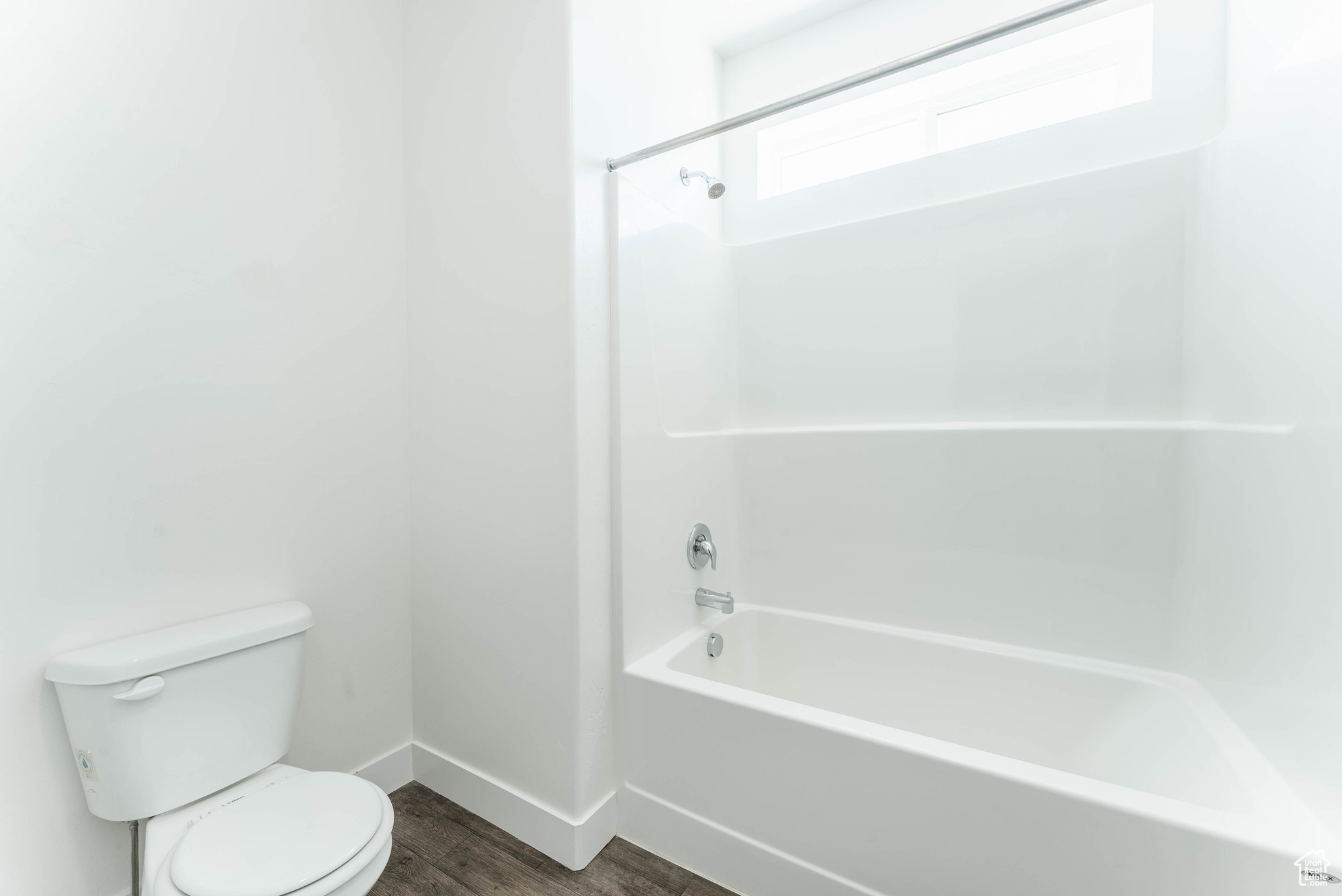 Bathroom with toilet, hardwood / wood-style floors, and shower / bathing tub combination