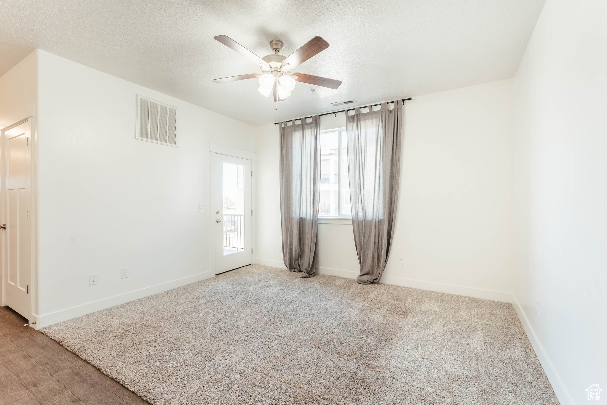 Unfurnished room with ceiling fan and light wood-type flooring