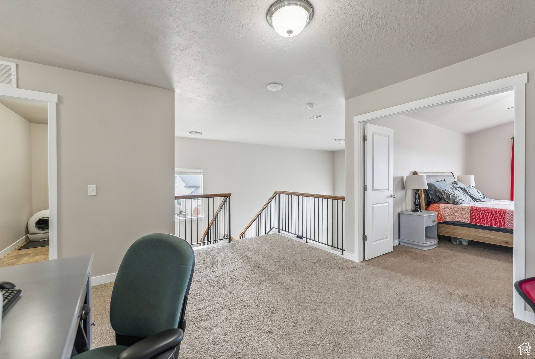 Carpeted office featuring a textured ceiling