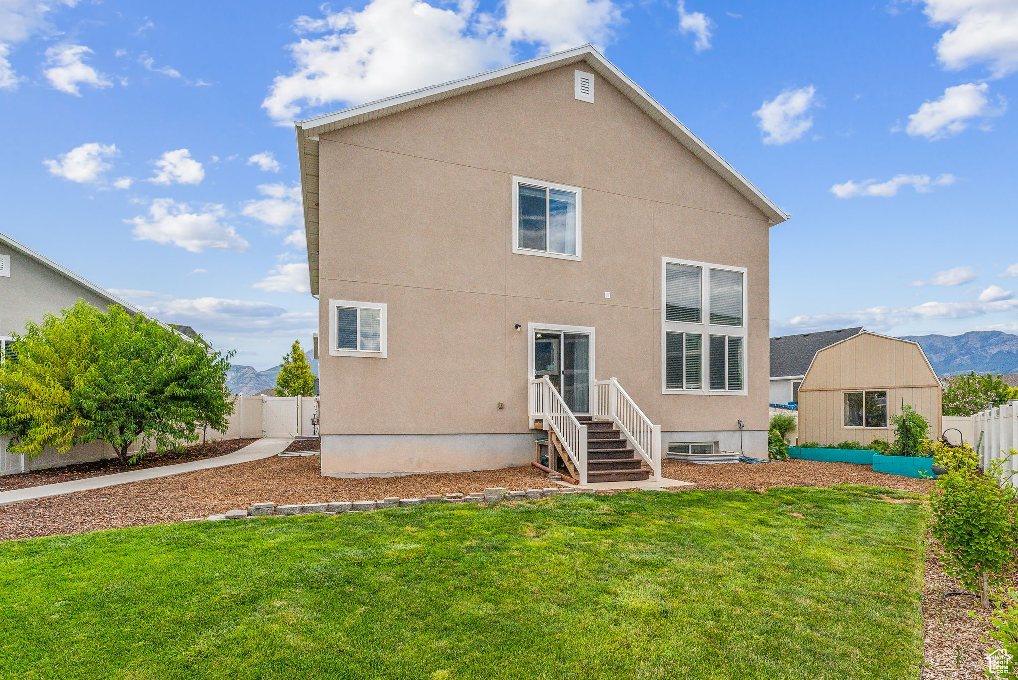 Rear view of property featuring a mountain view and a lawn