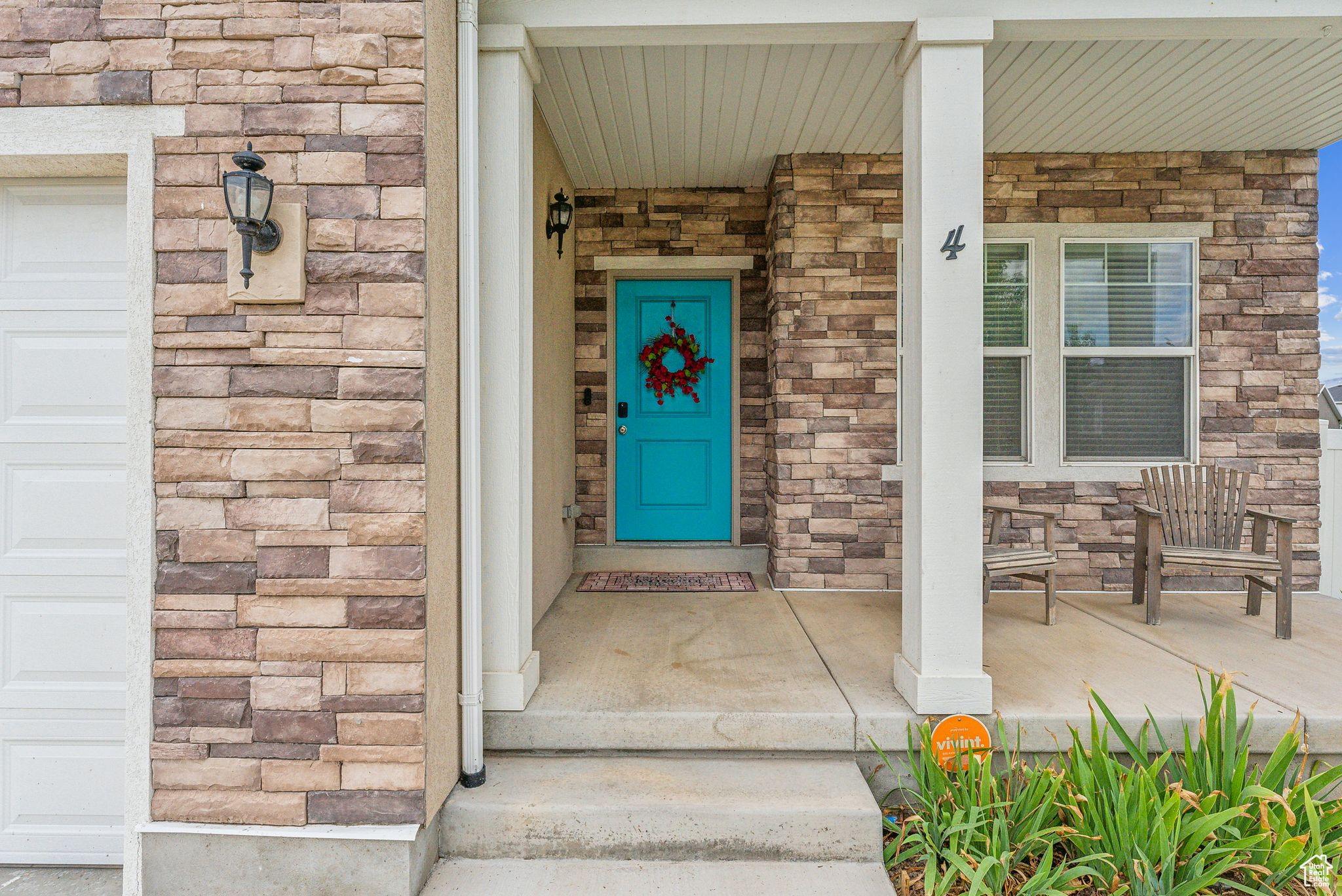 View of exterior entry featuring a garage and covered porch