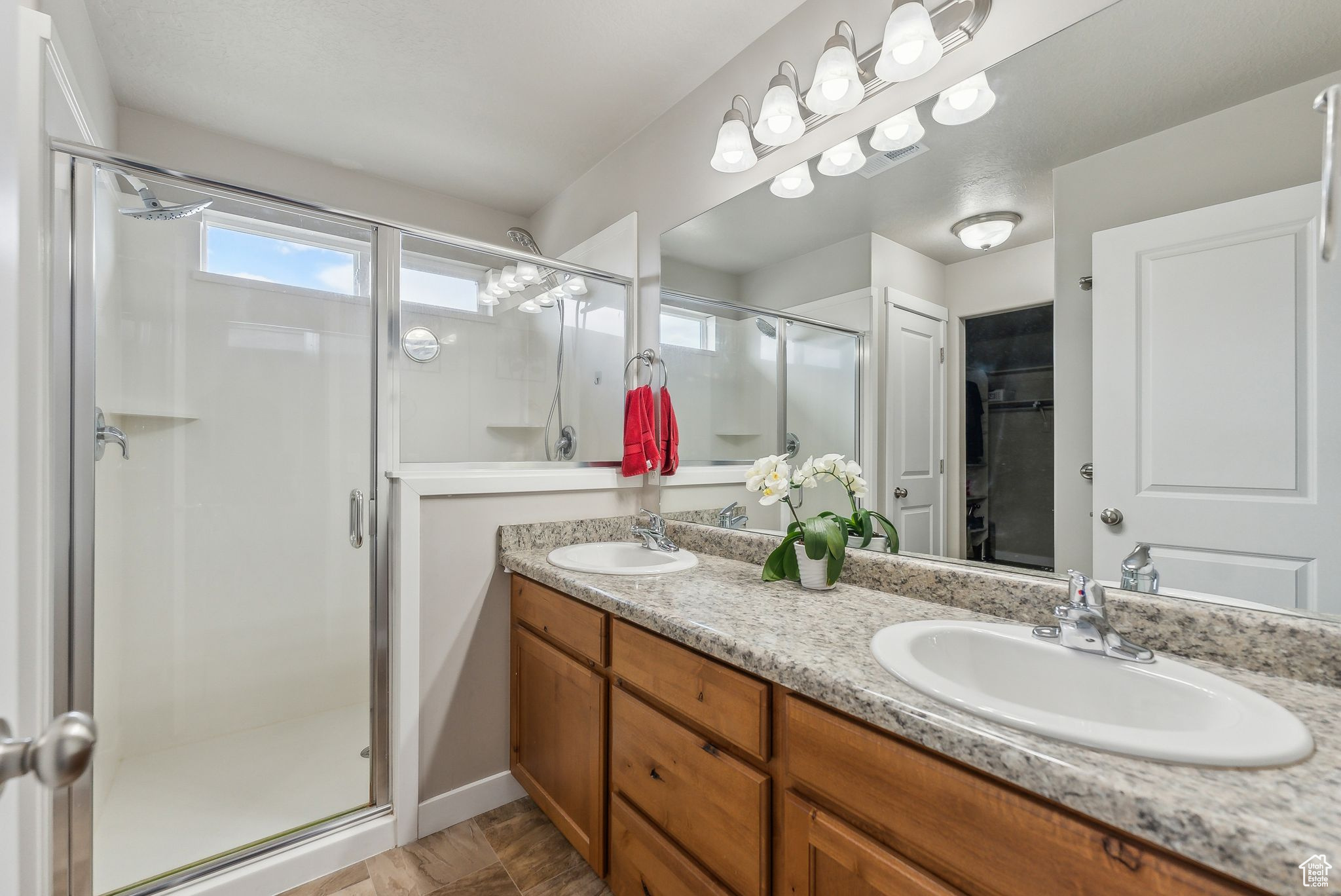 Bathroom featuring tile patterned flooring, an enclosed shower, and vanity