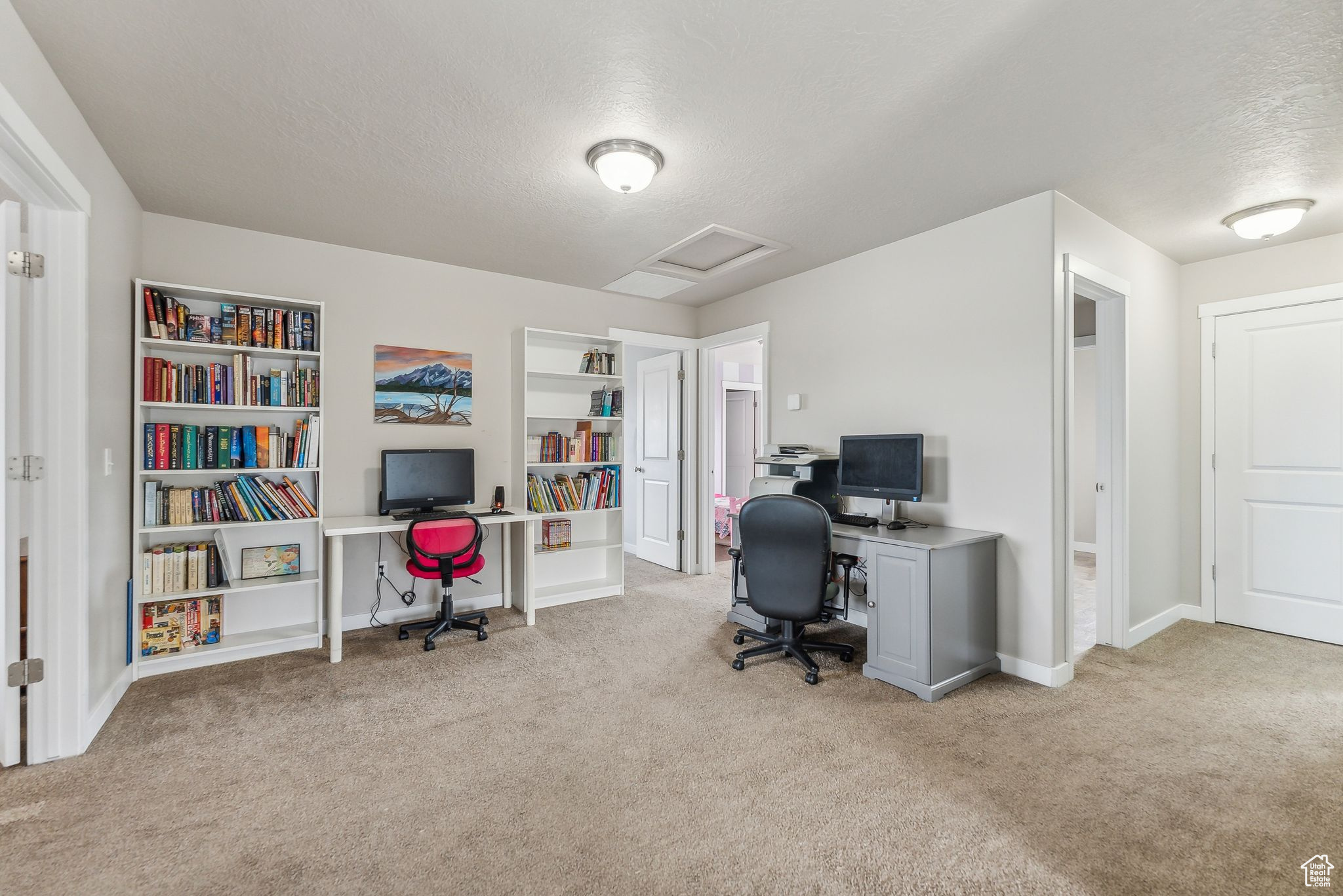 Carpeted home office with a textured ceiling