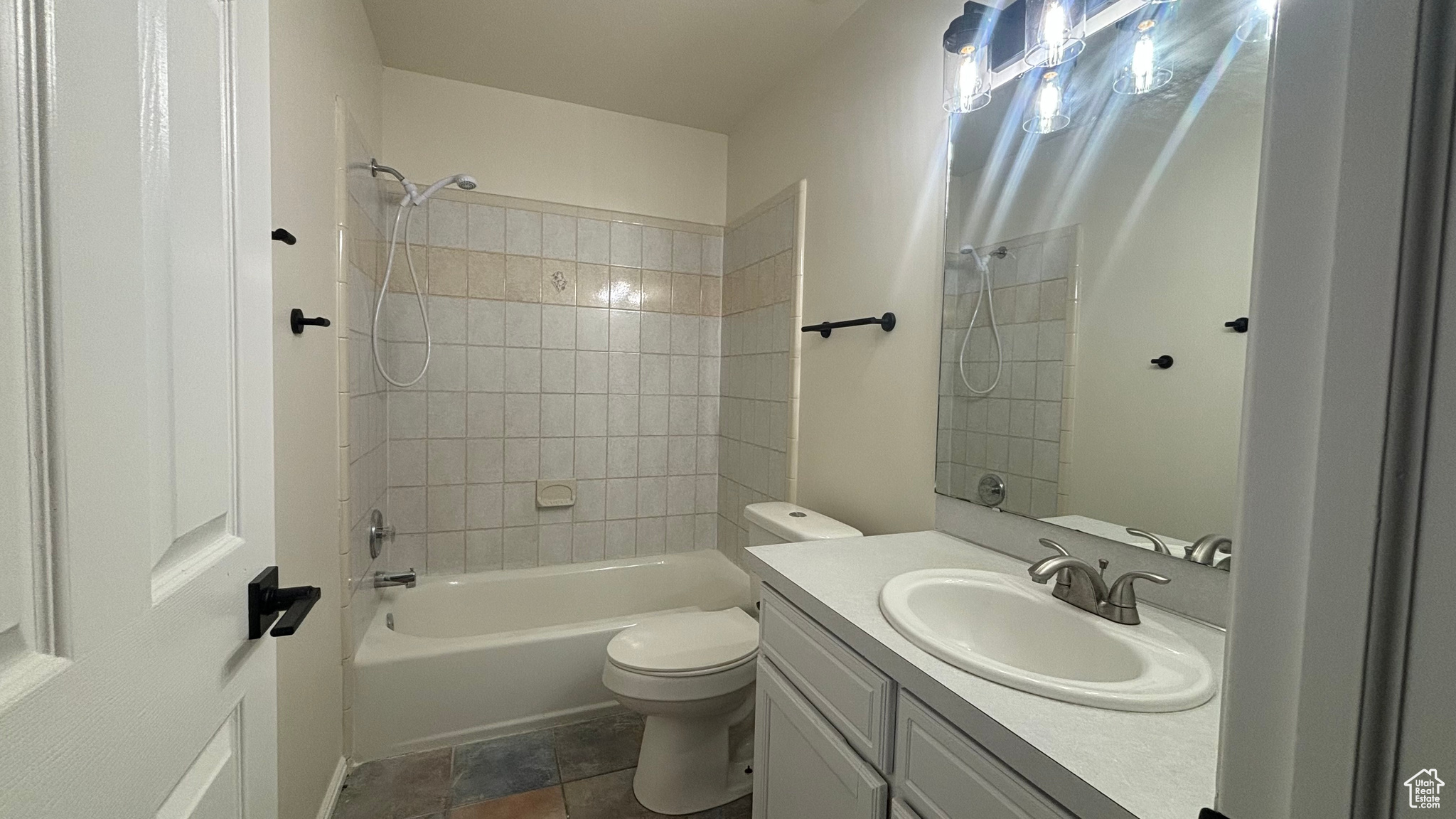 Full bathroom with vanity, toilet, and tiled shower / bath combo