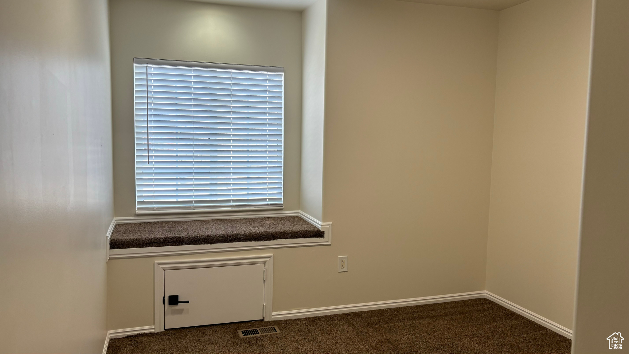 Unfurnished room featuring dark carpet