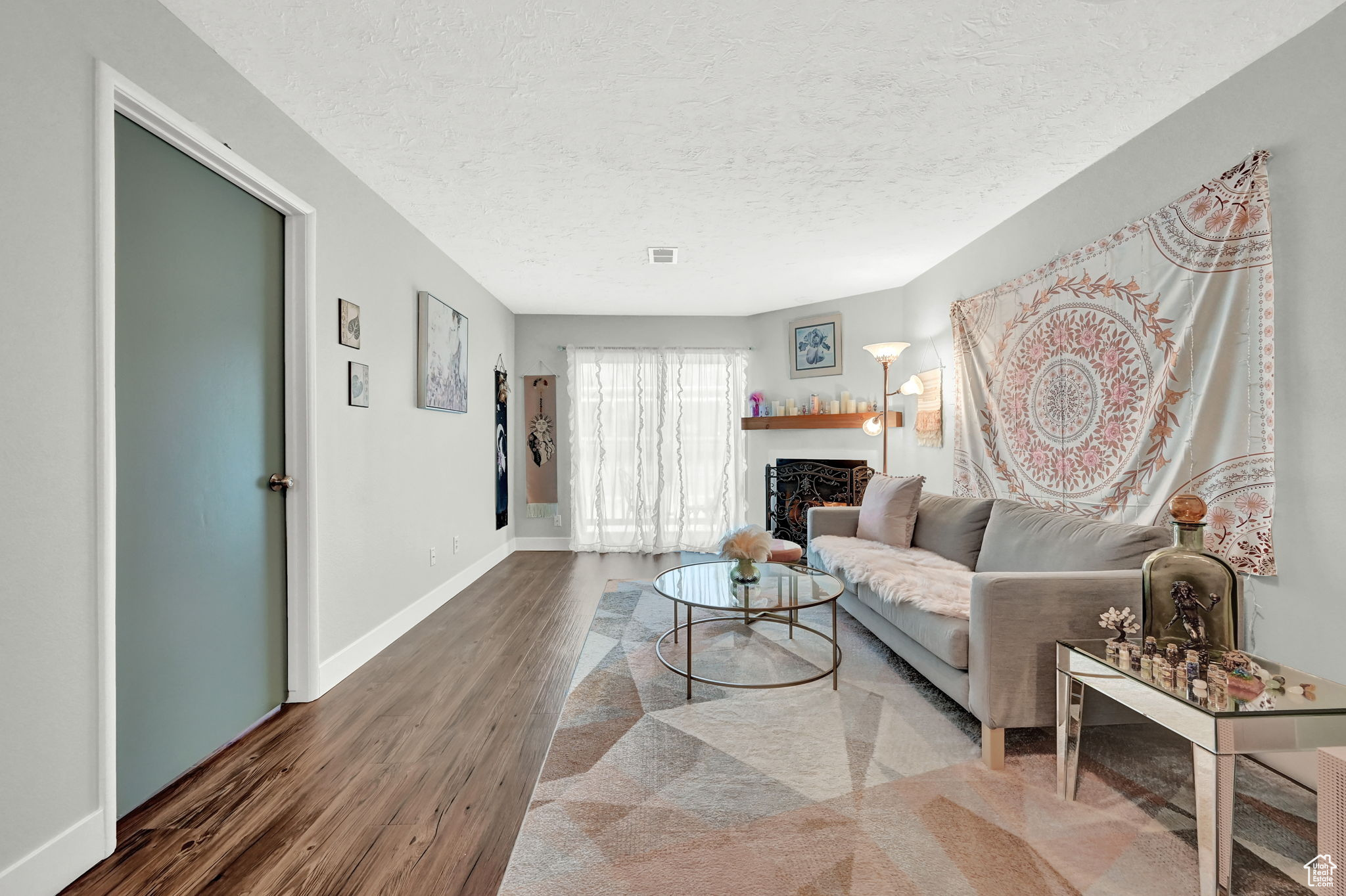 Living room featuring dark hardwood / wood-style flooring and a textured ceiling