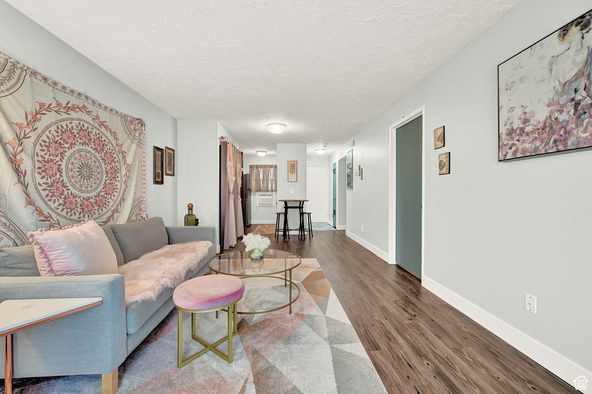 Living room featuring a textured ceiling and dark wood-type flooring