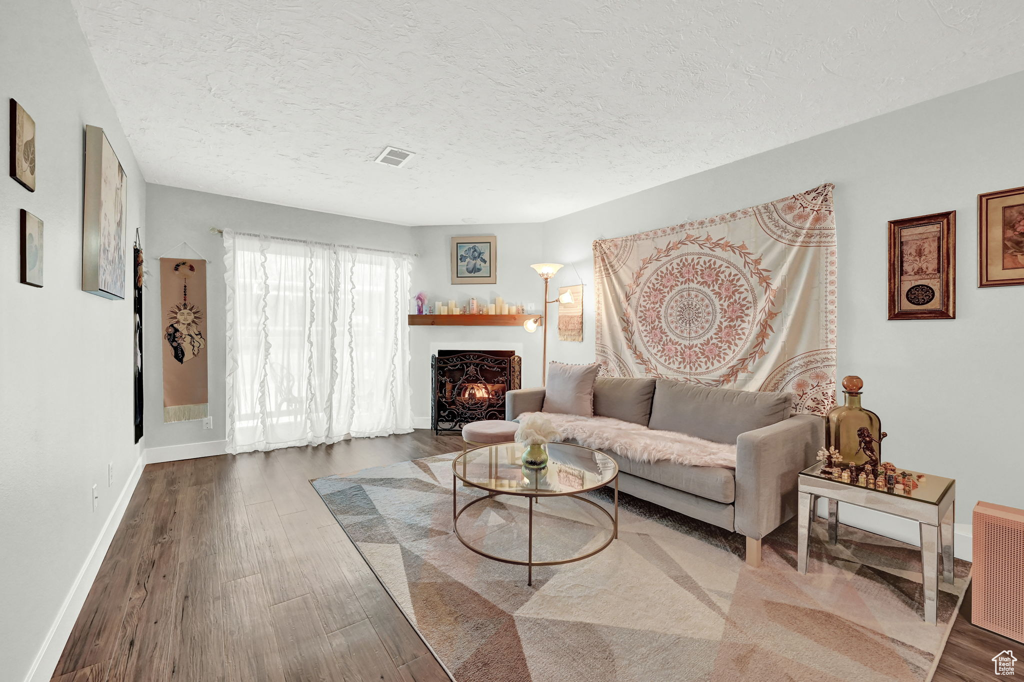 Living room with a textured ceiling and dark wood-type flooring