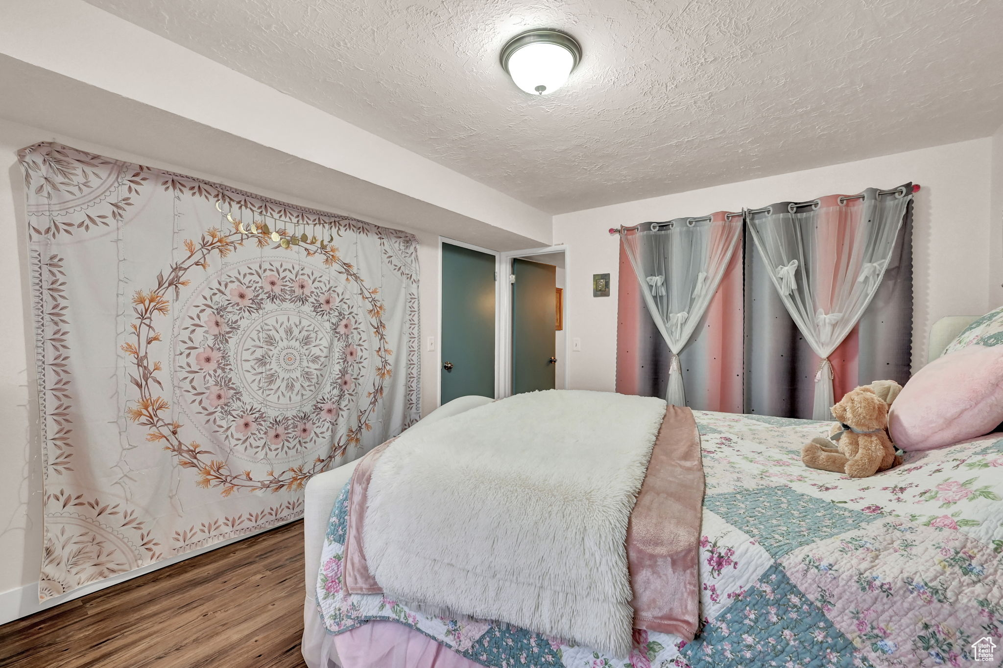 Bedroom featuring a textured ceiling and hardwood / wood-style flooring