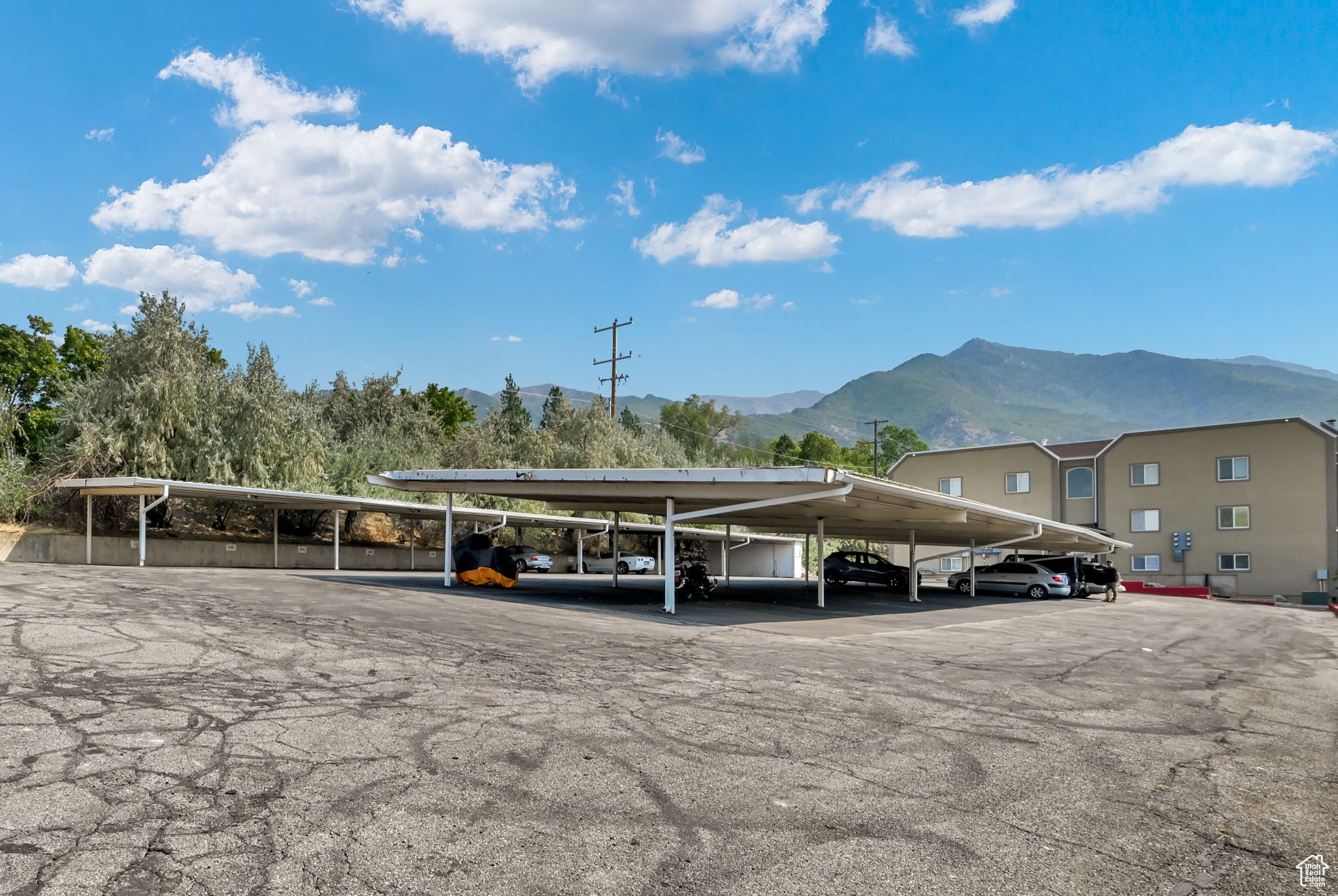 View of parking with a mountain view and a carport