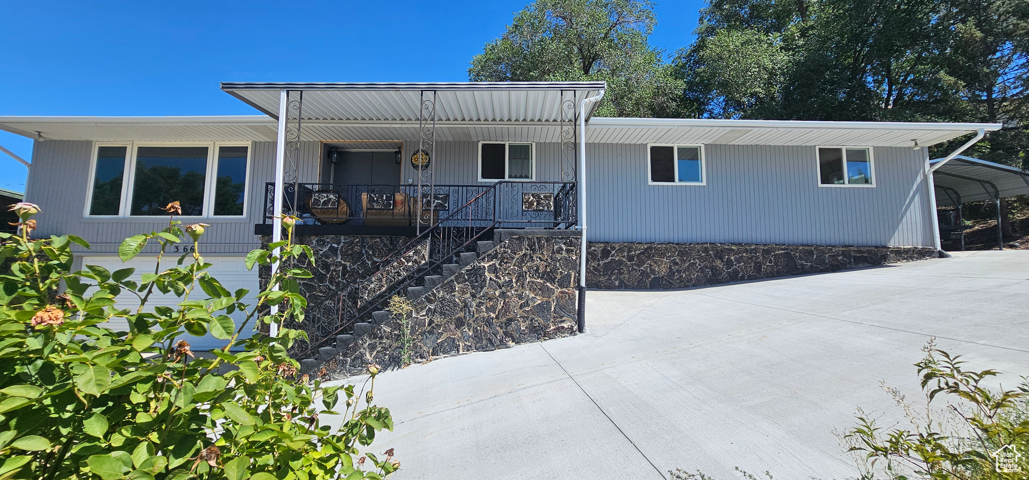 View of front facade with a carport and a porch