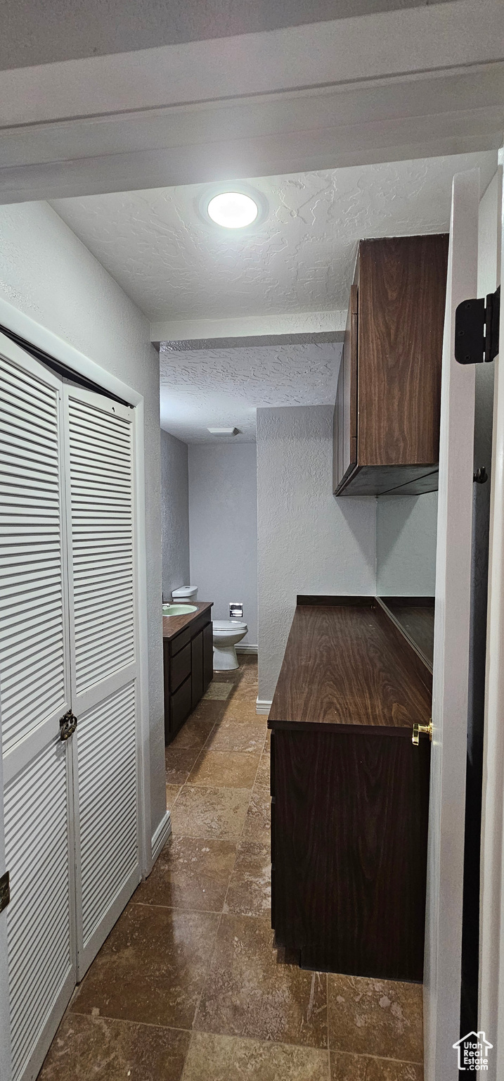 Kitchen with a textured ceiling and dark brown cabinetry