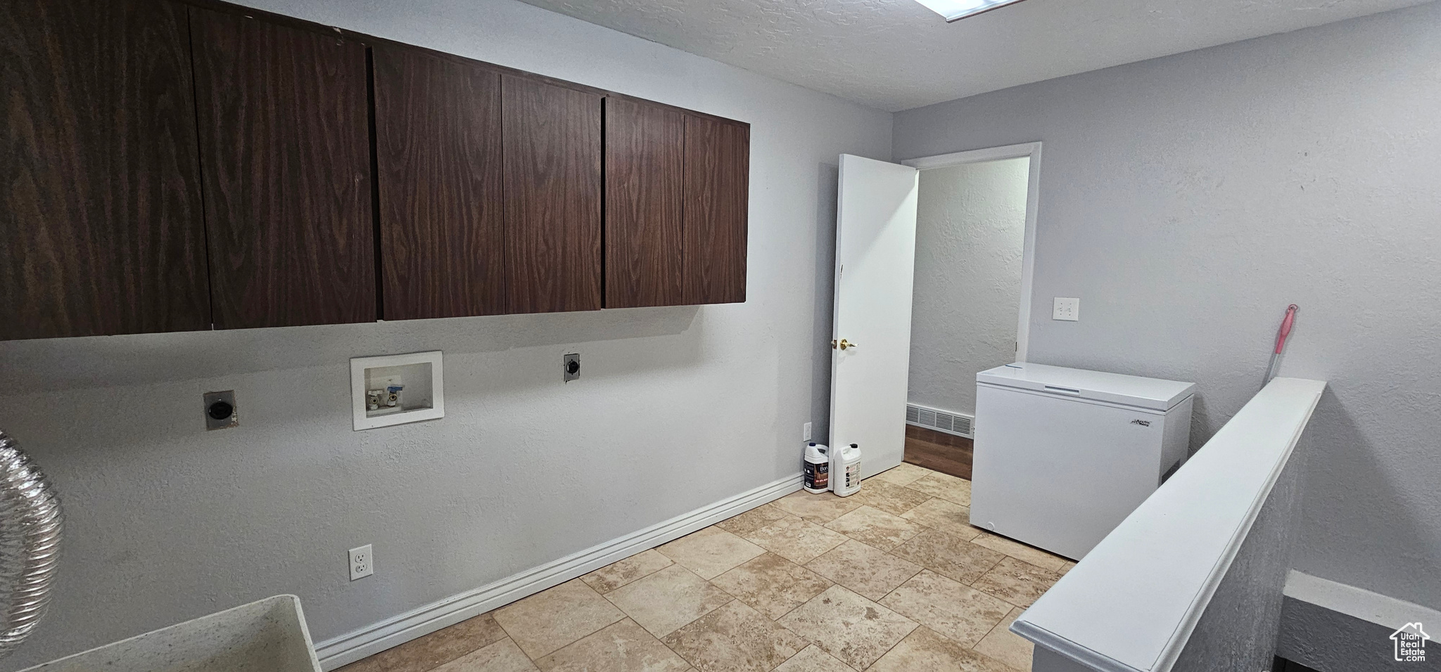 Clothes washing area with washer hookup, electric dryer hookup, and cabinets