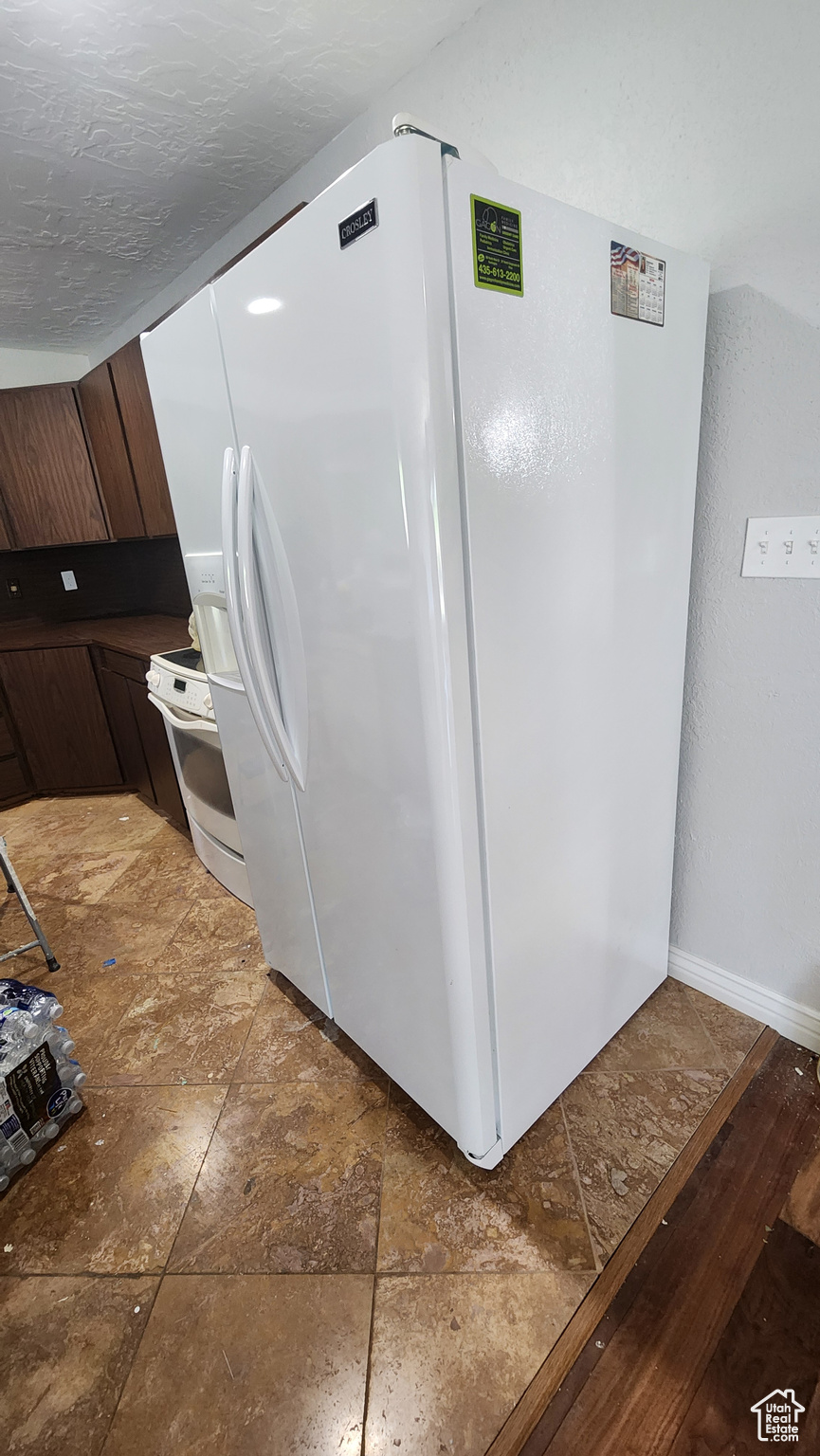 Interior space featuring tile patterned flooring and white appliances