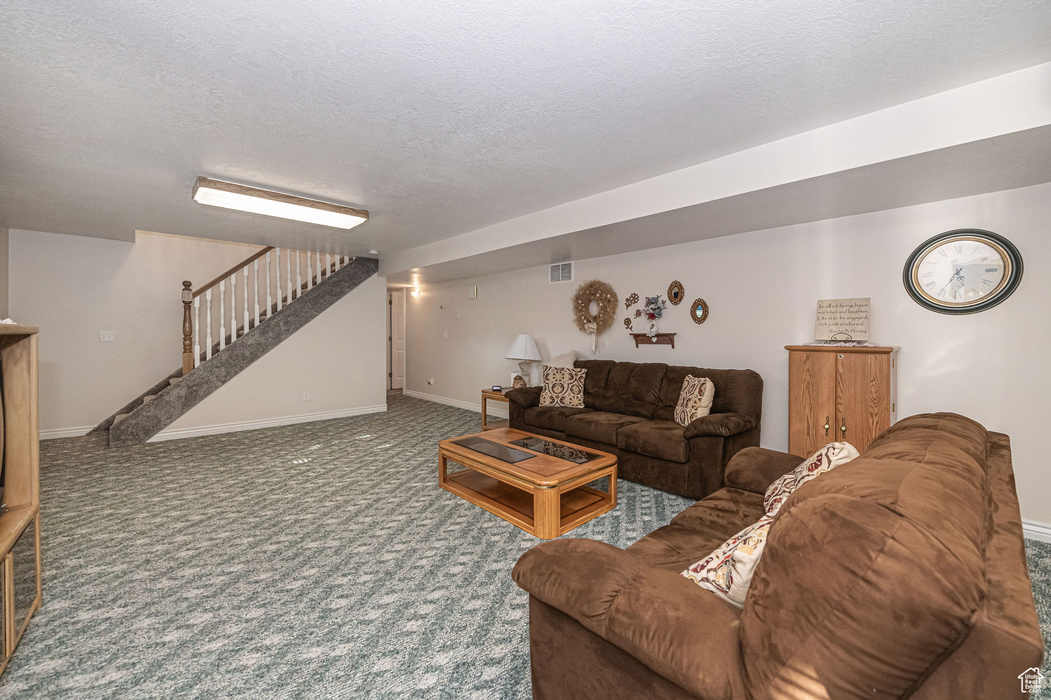 Living room featuring carpet and a textured ceiling