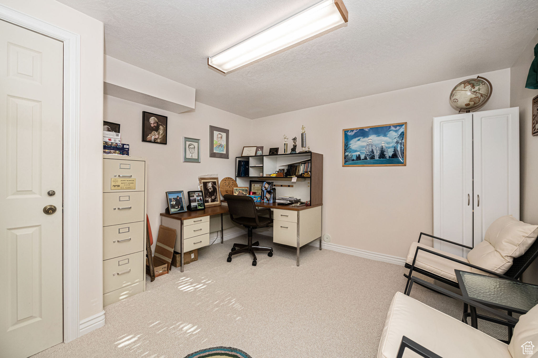 Office area or bedroom featuring light colored carpet