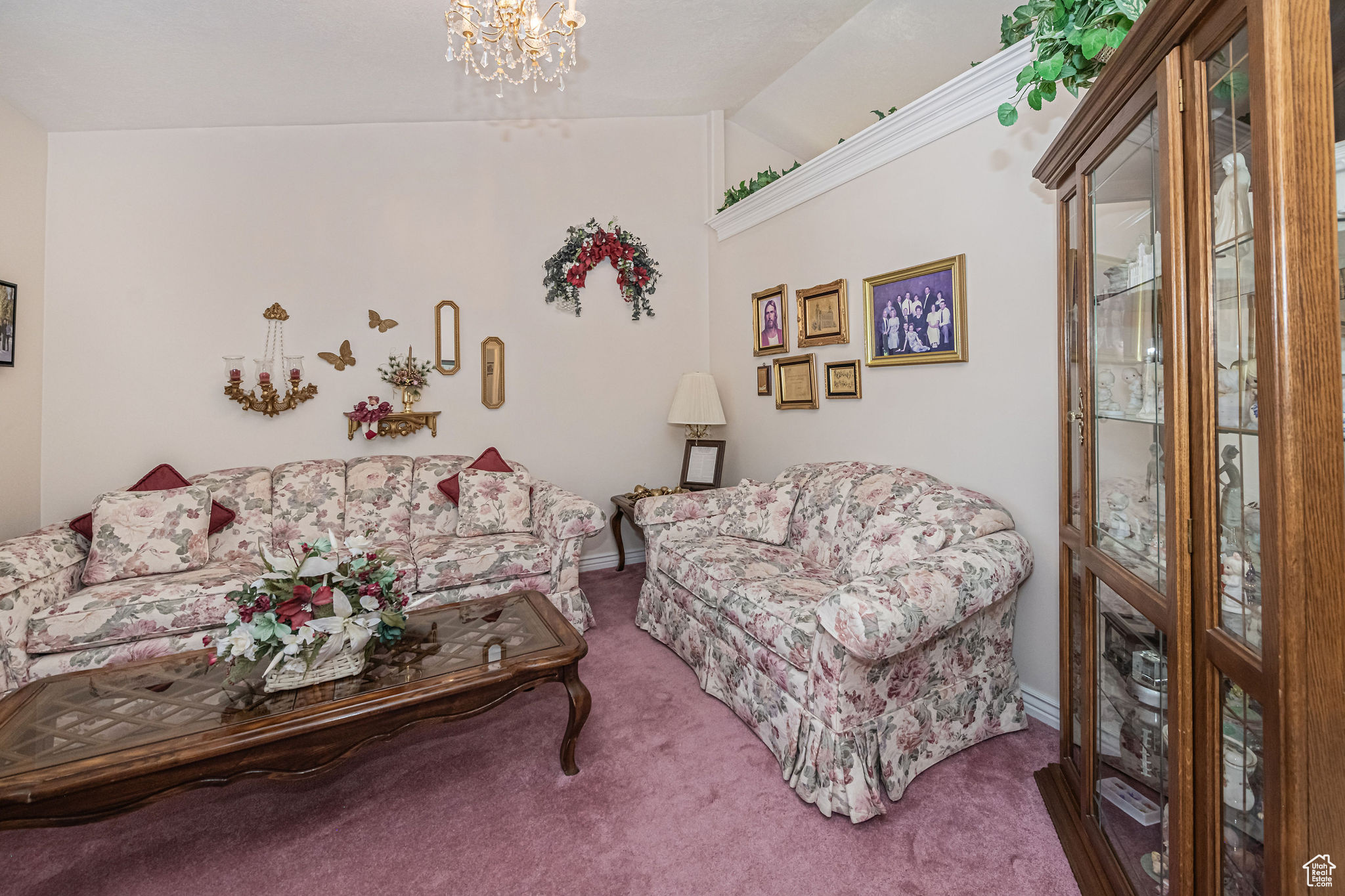 Carpeted living room featuring a notable chandelier and lofted ceiling