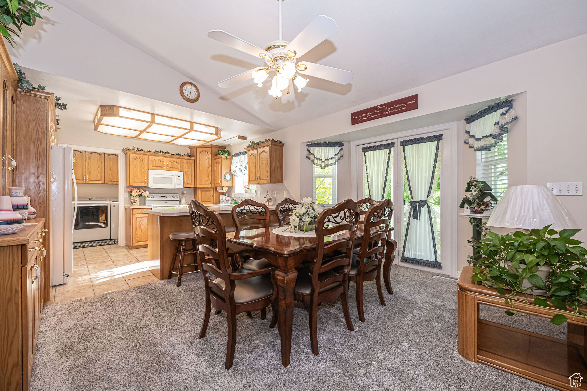 Tiled dining room featuring ceiling fan, plenty of natural light, and lofted ceiling