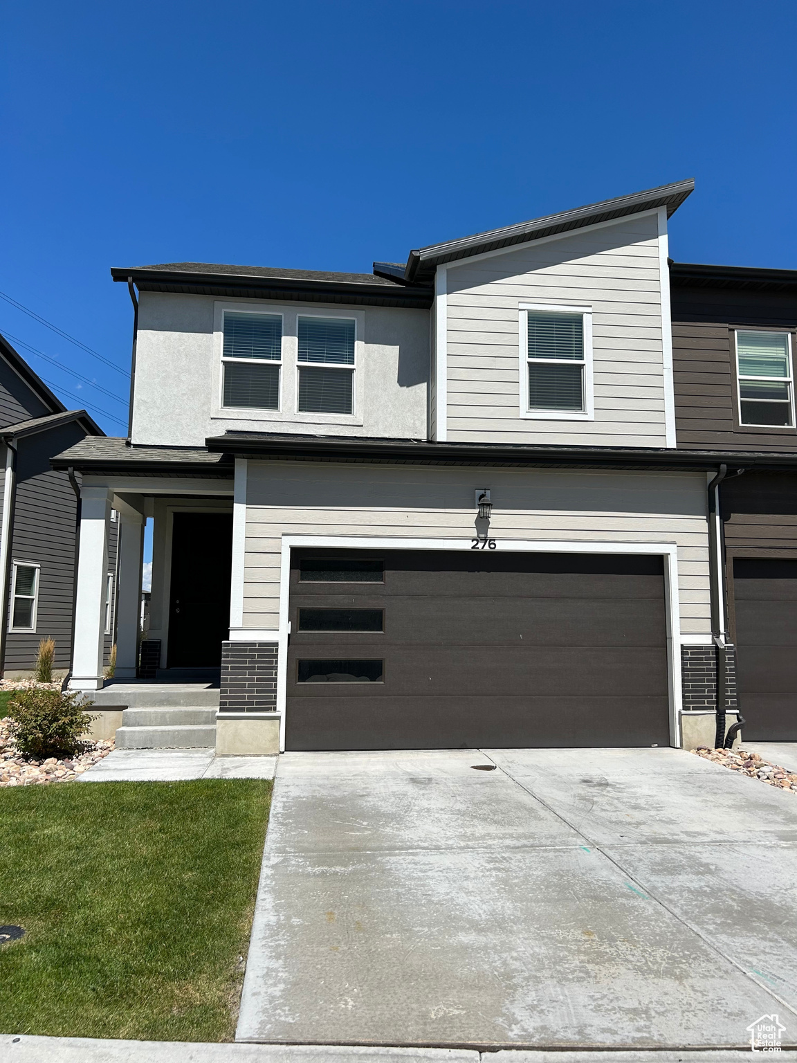 View of front of property featuring a 2 car garage and a front yard.