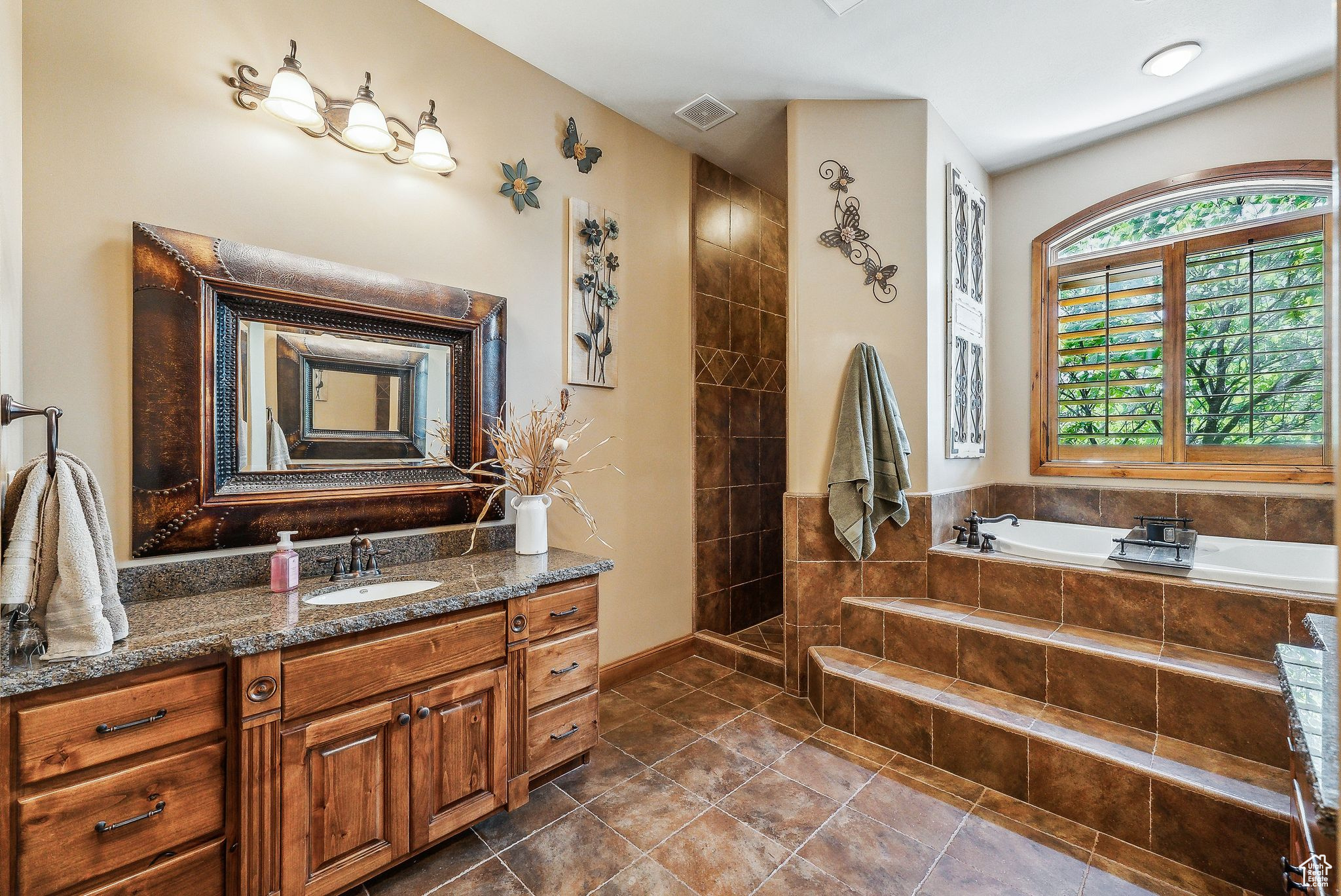 Bathroom featuring vanity, plus walk in shower, and tile patterned flooring