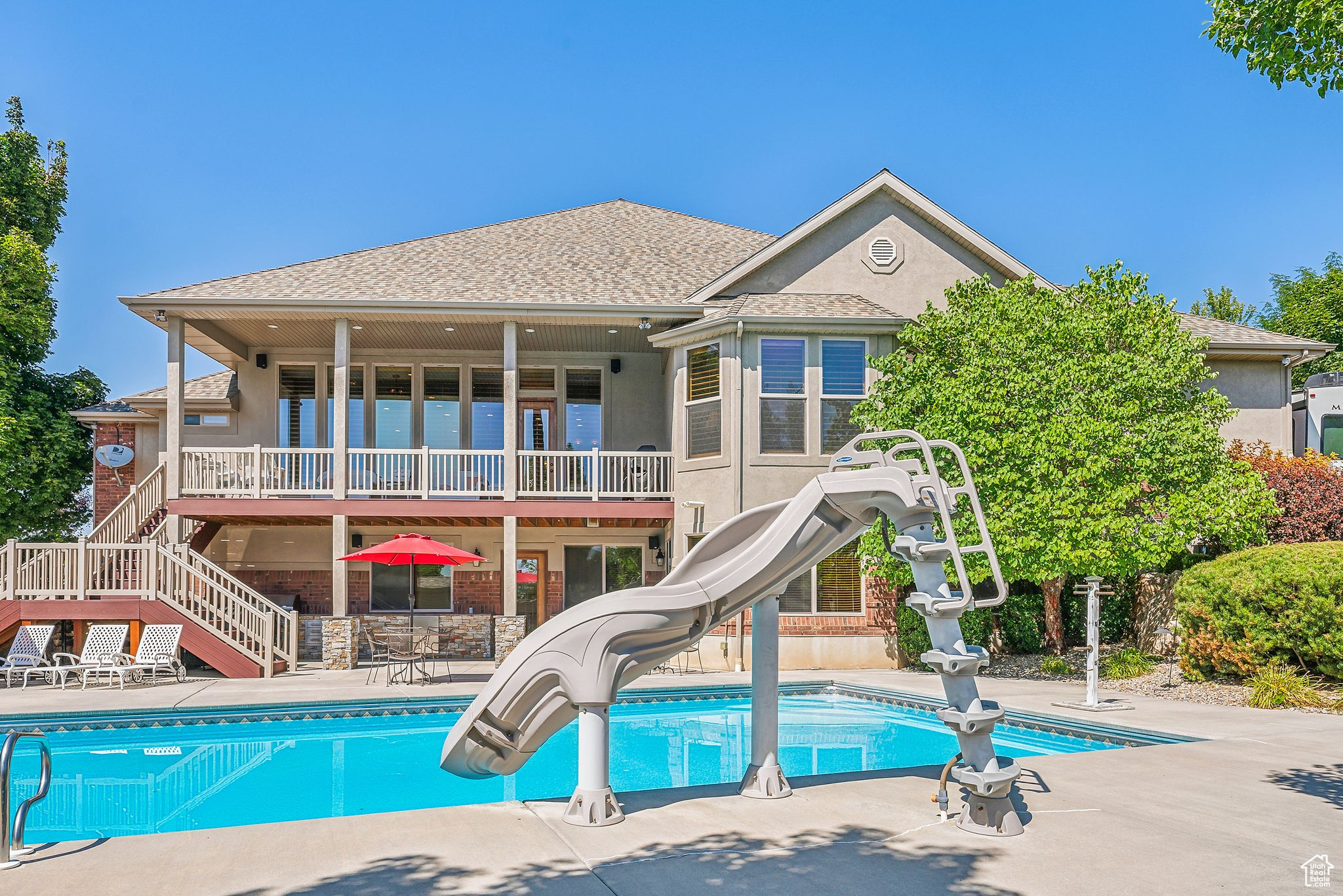 View of pool featuring a water slide and a patio