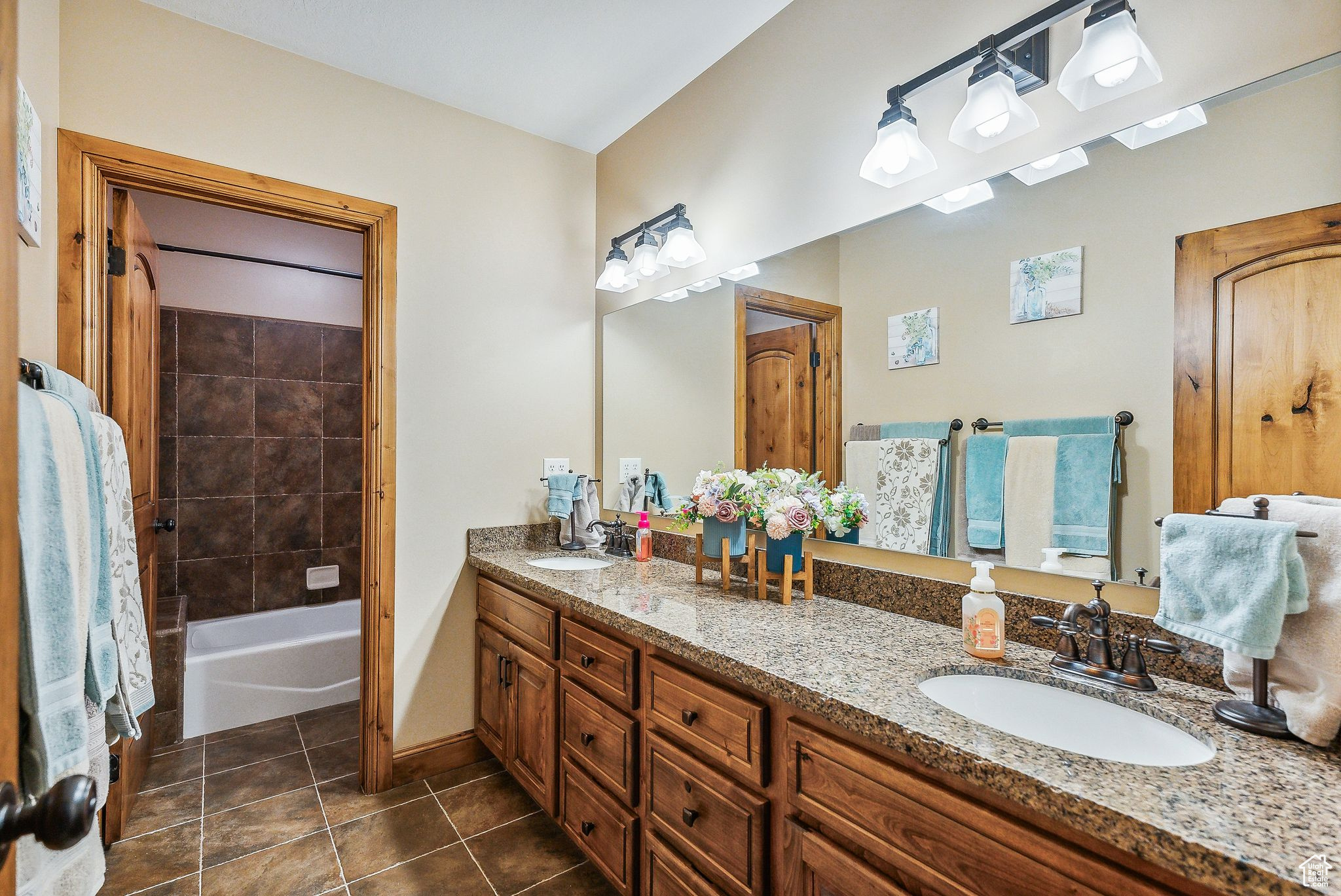 Bathroom featuring vanity,  shower combination, and tile patterned flooring