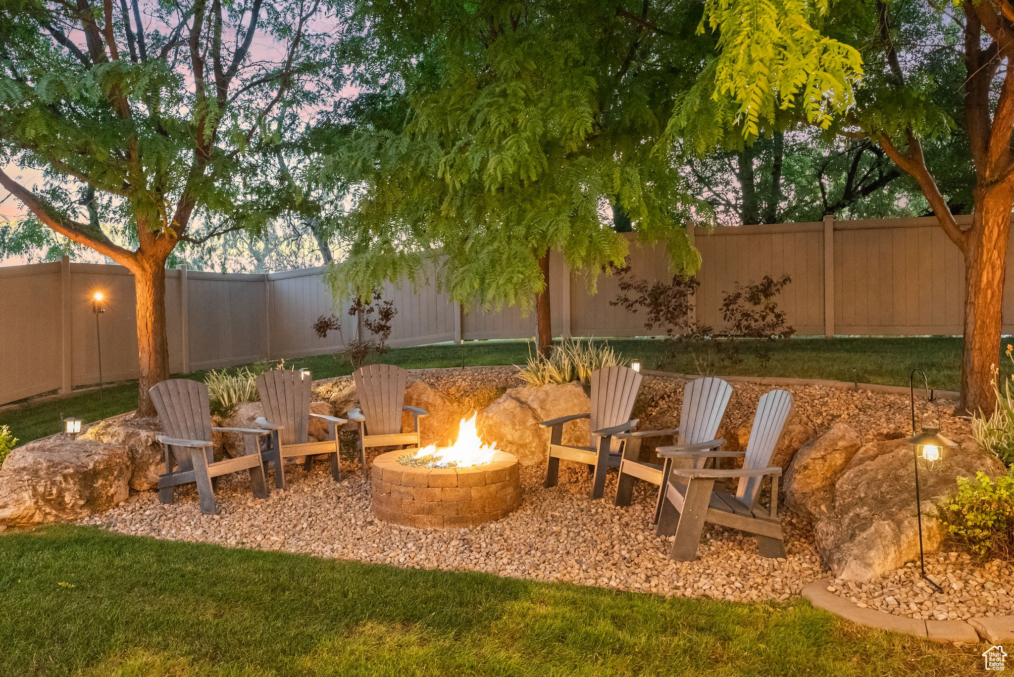 Yard at dusk with an outdoor fire pit and a patio