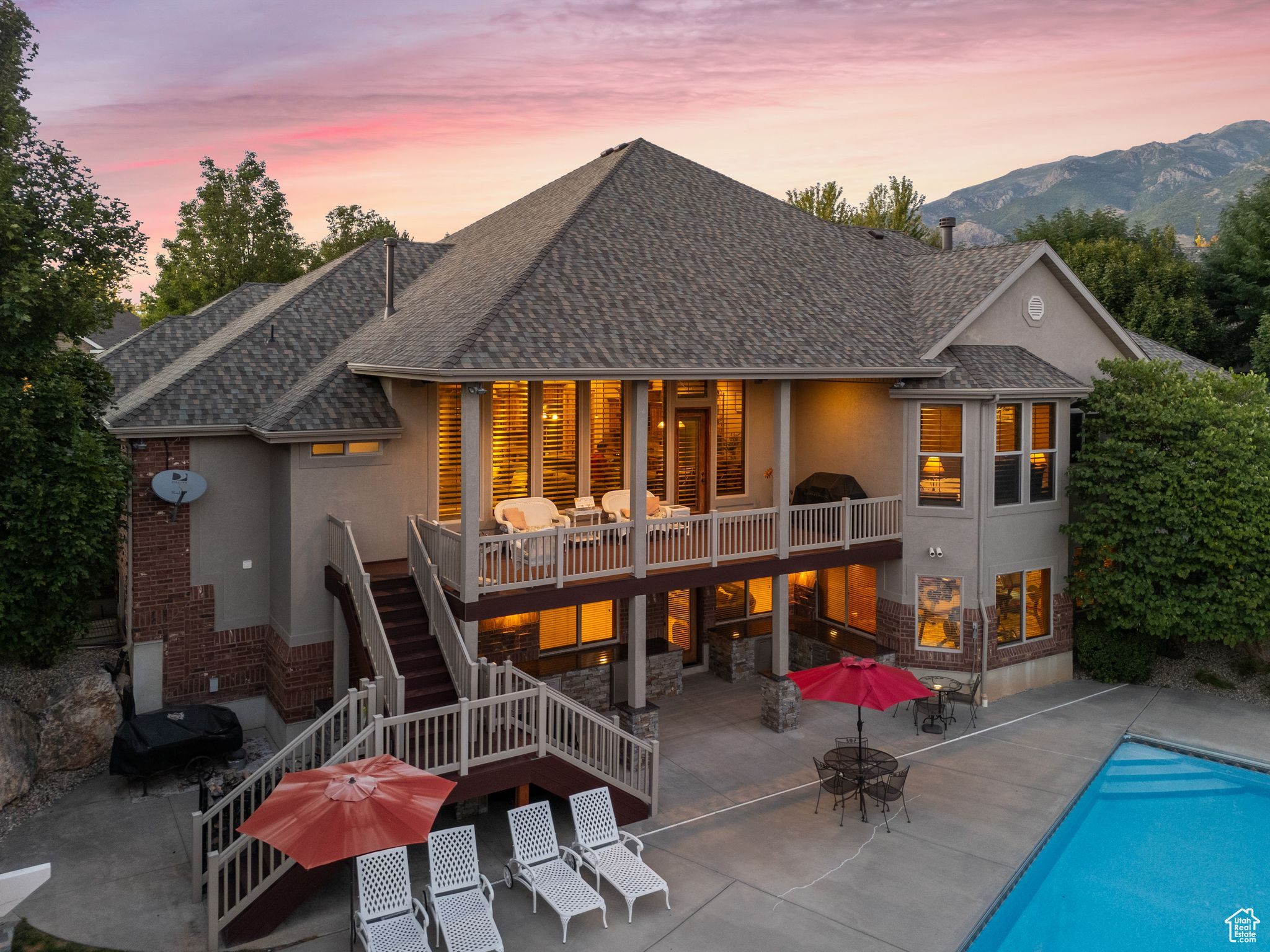 Back house at dusk with a mountain view and a patio area