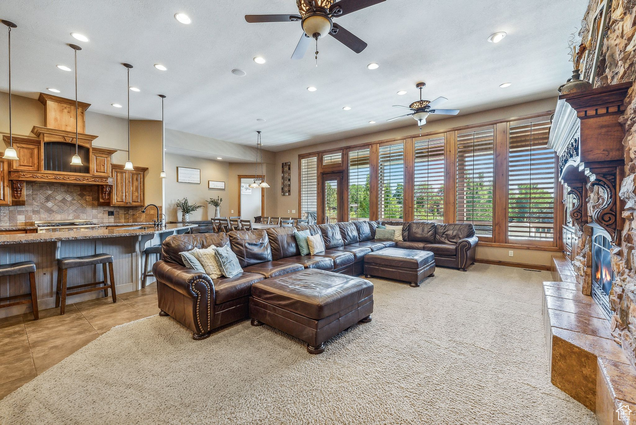 Tiled living room featuring ceiling fan and a fireplace