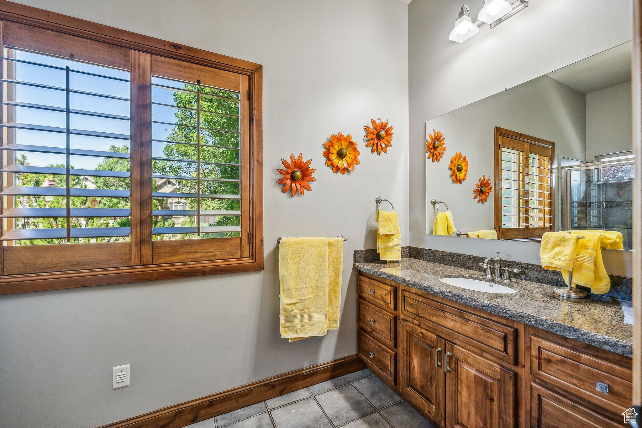 Bathroom featuring tile patterned flooring, vanity, and a shower with shower door