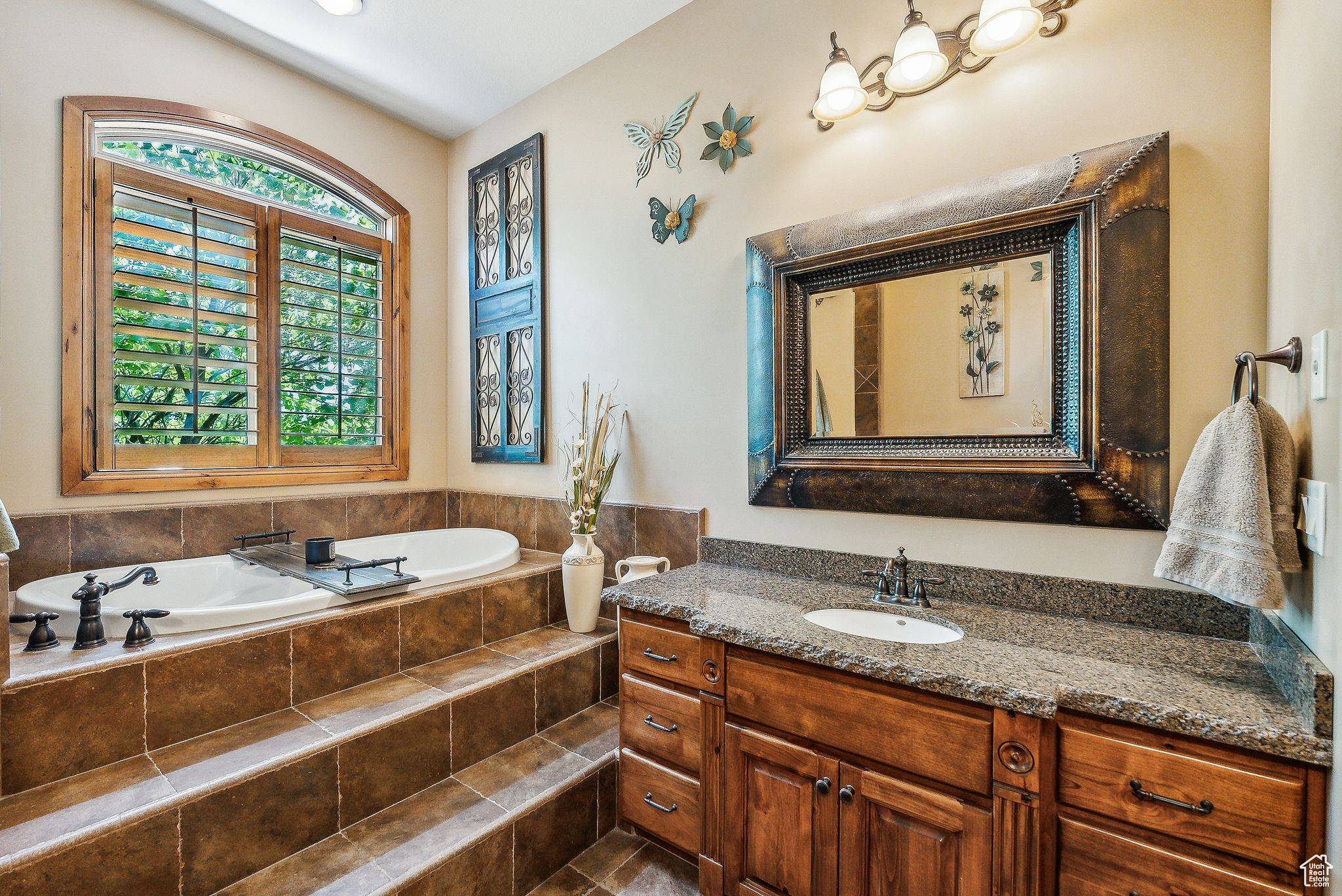 Bathroom featuring vanity, plenty of natural light, and tiled bath