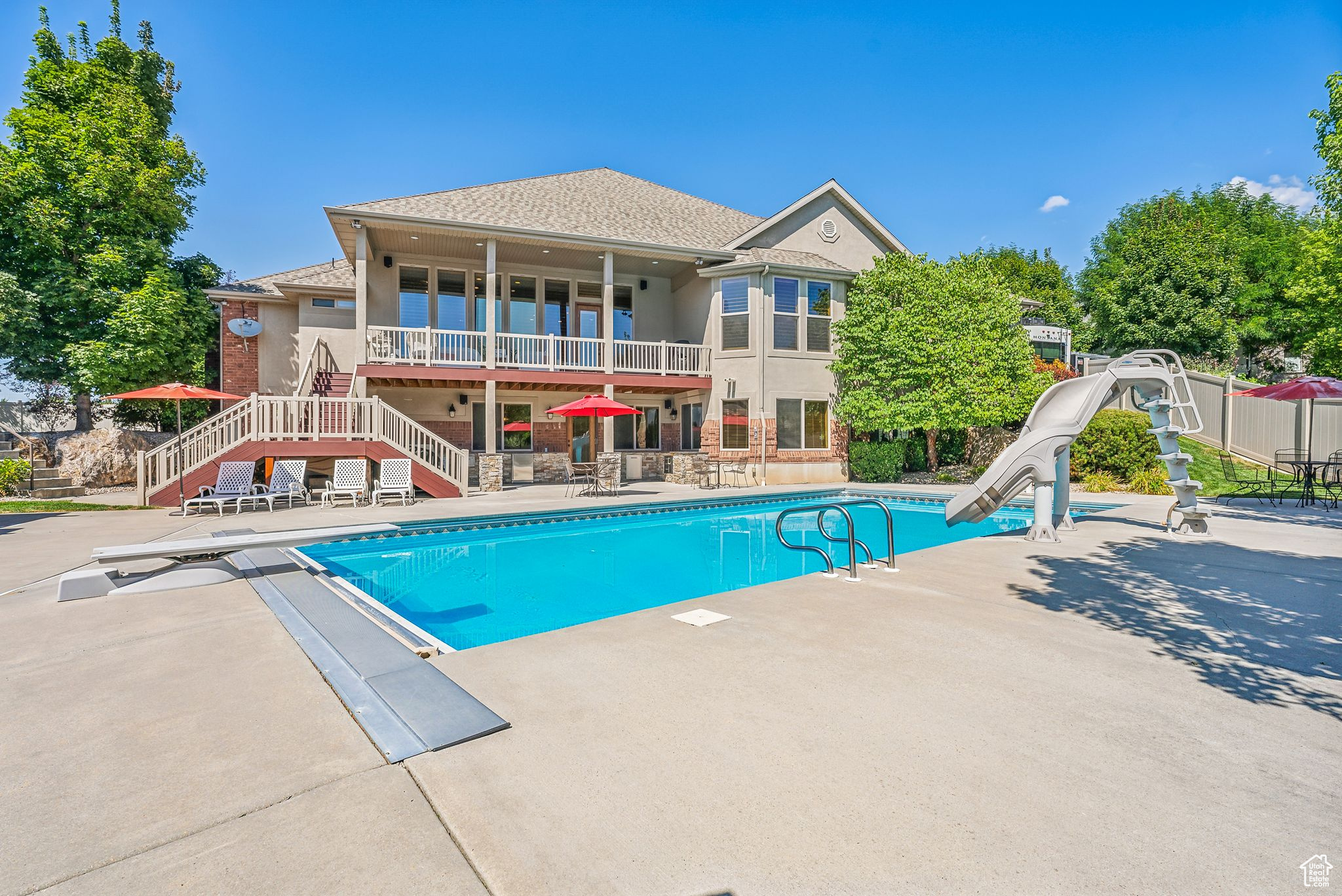 View of pool with a water slide, a diving board, and a patio