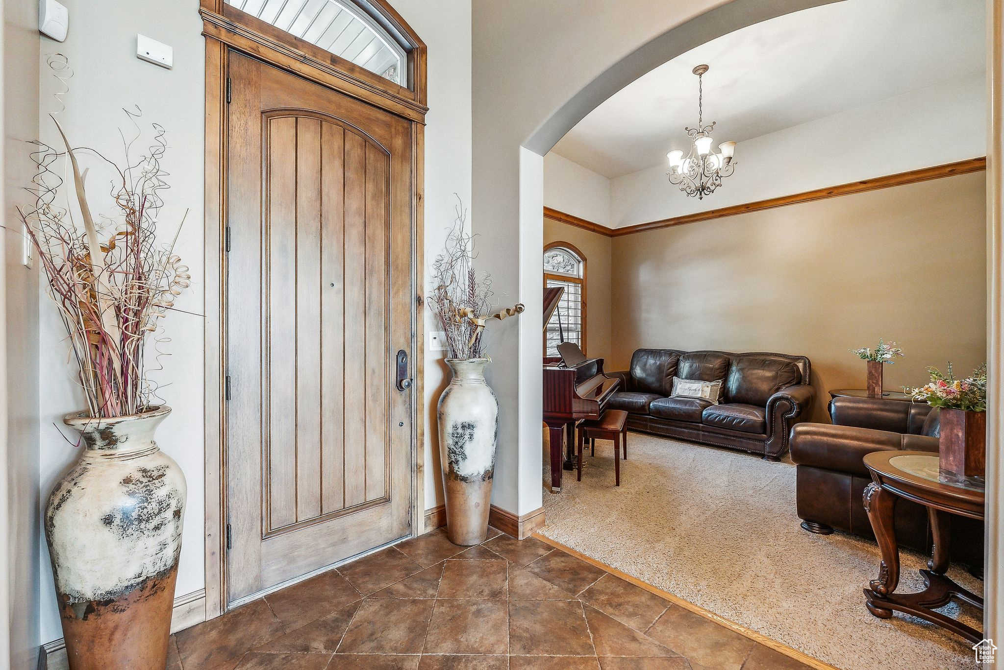 Foyer featuring dark colored carpet and an inviting chandelier