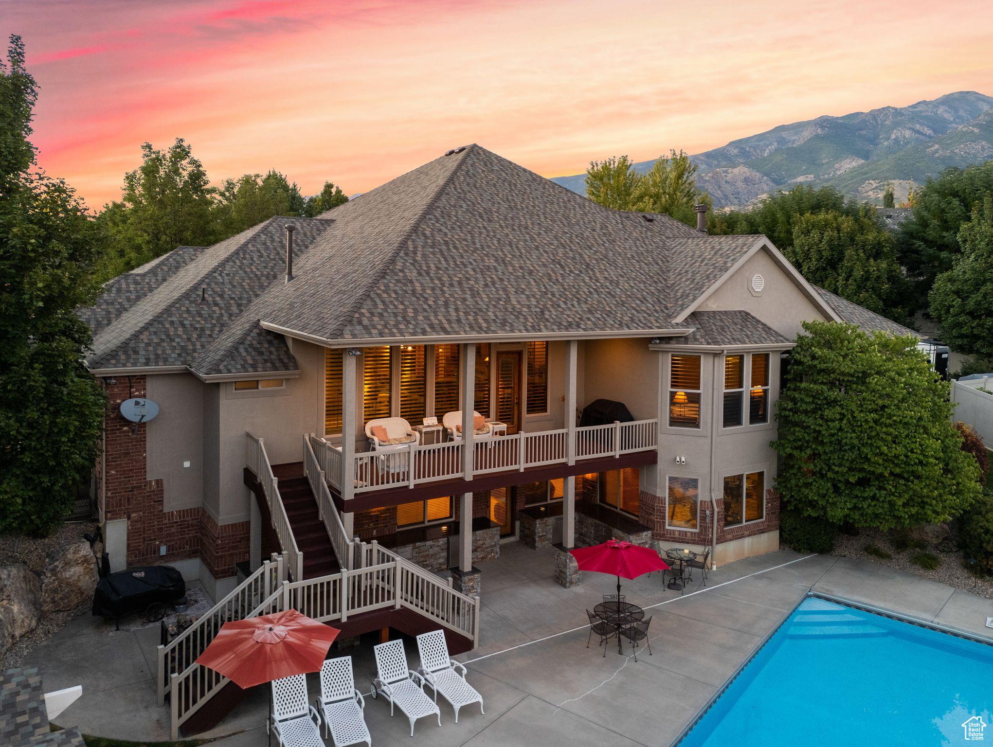 Back house at dusk featuring a patio and a mountain view